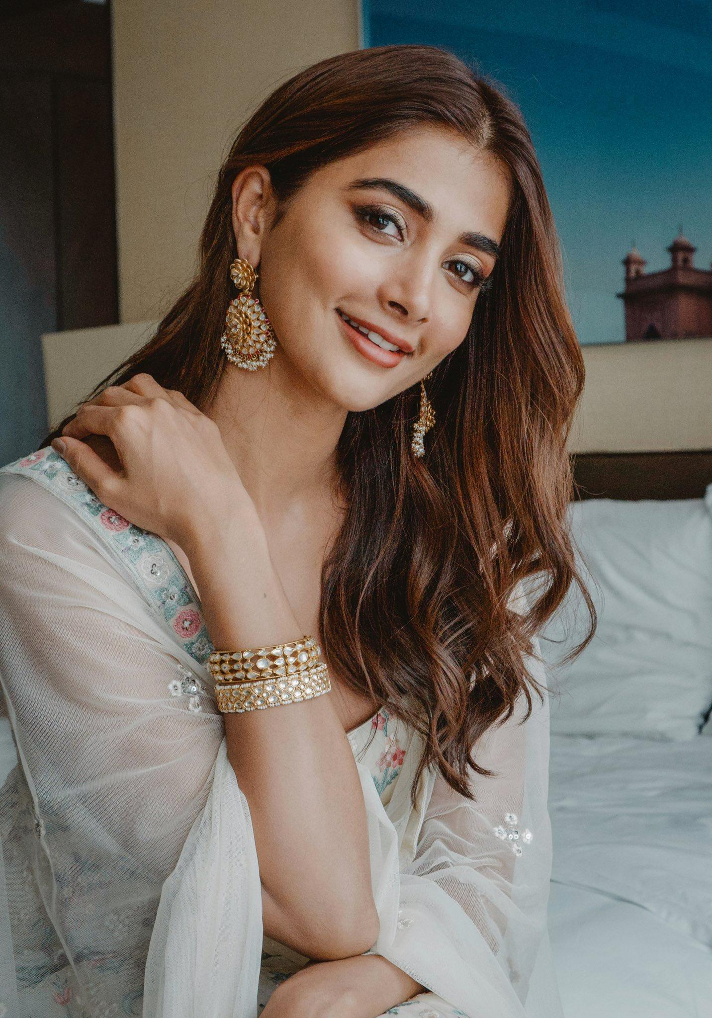 Pooja Hegde Smiling in a White Saree with Gold Jewelry