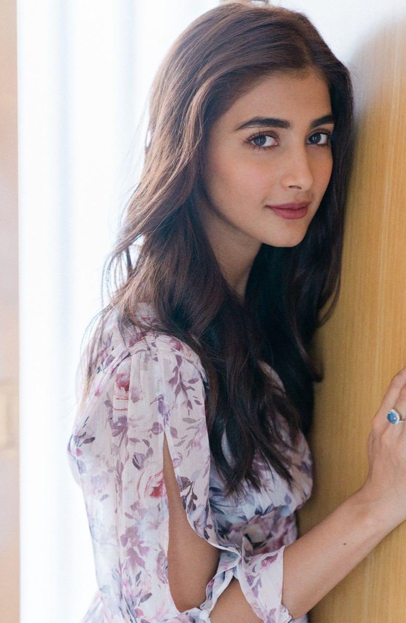 Pooja Hegde Smiling Softly in Floral Dress Near Wooden Wall