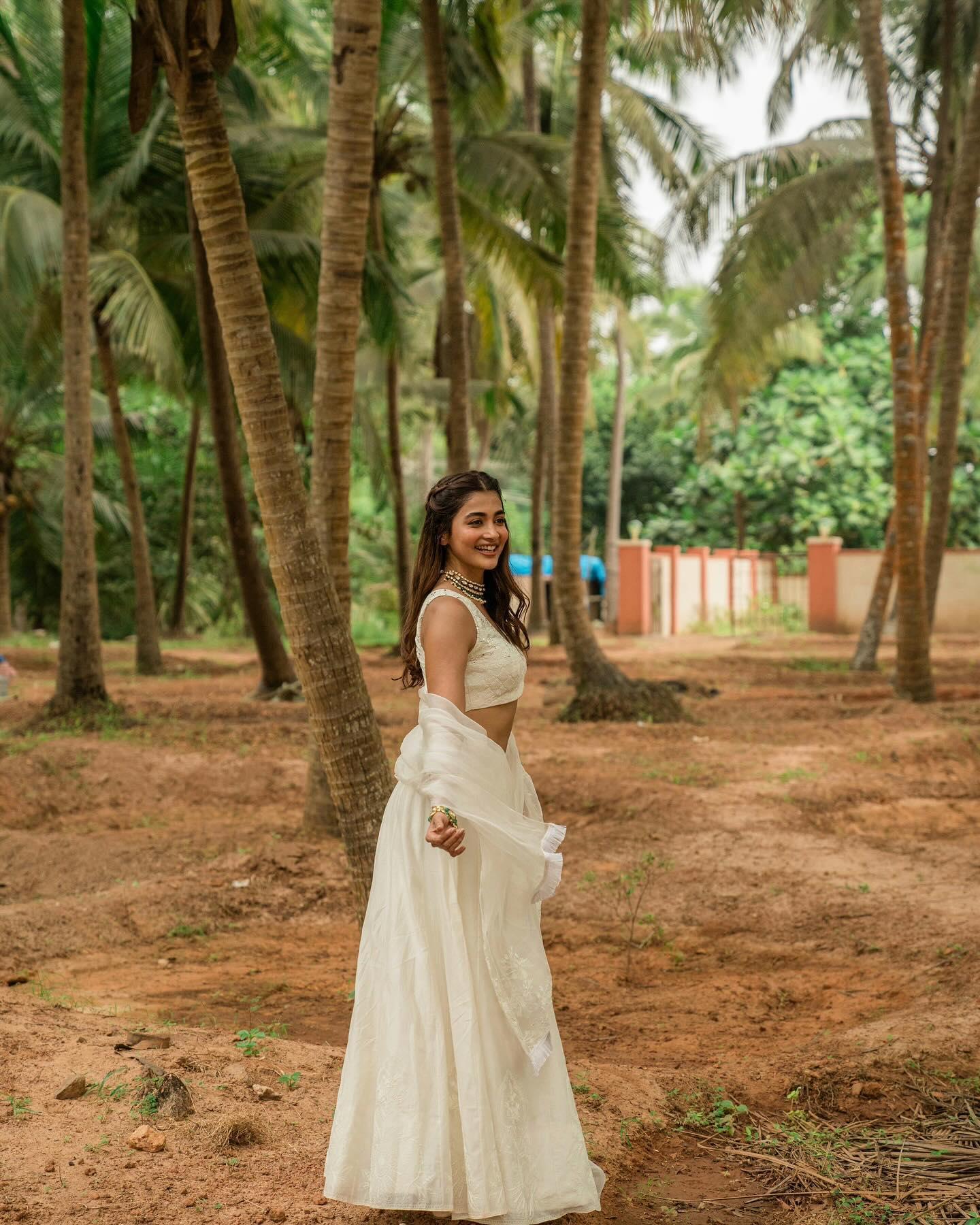 Pooja Hegde Walking in White Dress Under Tall Palm Trees