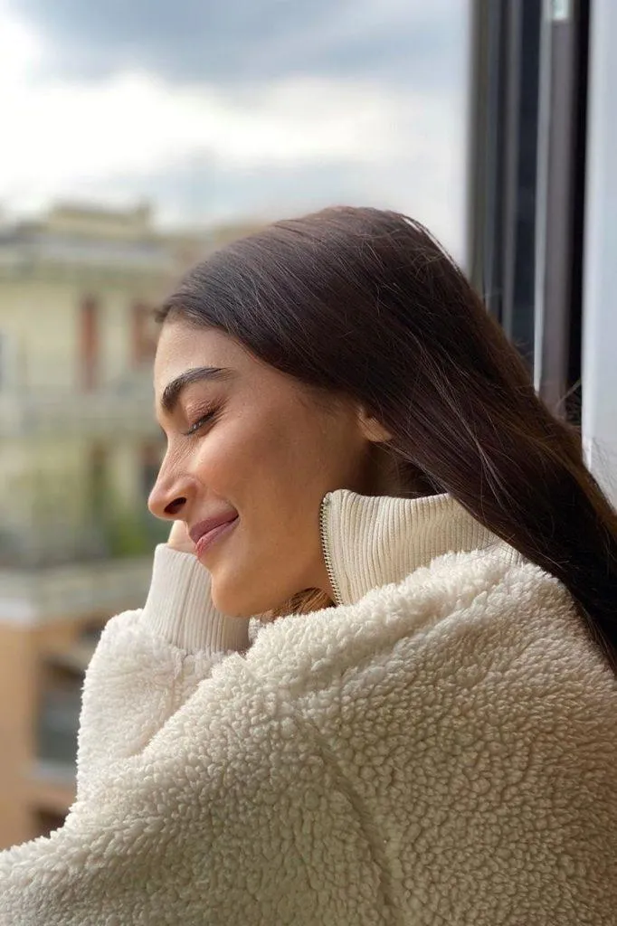 Pooja Hegde Enjoys a Cozy Moment in a Warm White Sweater