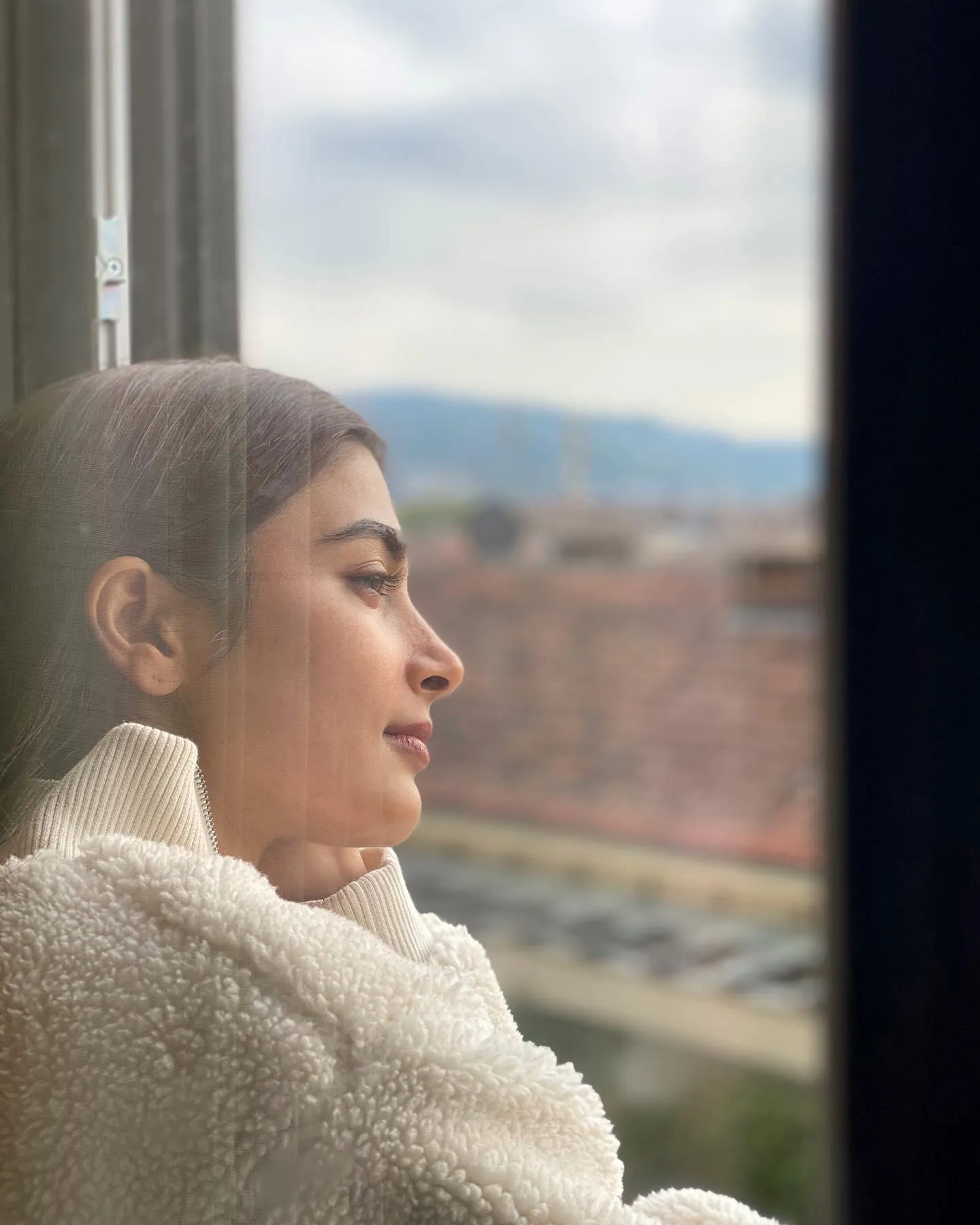 Pooja Hegde Gazing Out Window in Cozy Sweater Wallpaper