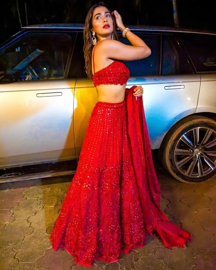 Pooja Hegde in a Stunning Red Lehenga Beside a Luxury Car