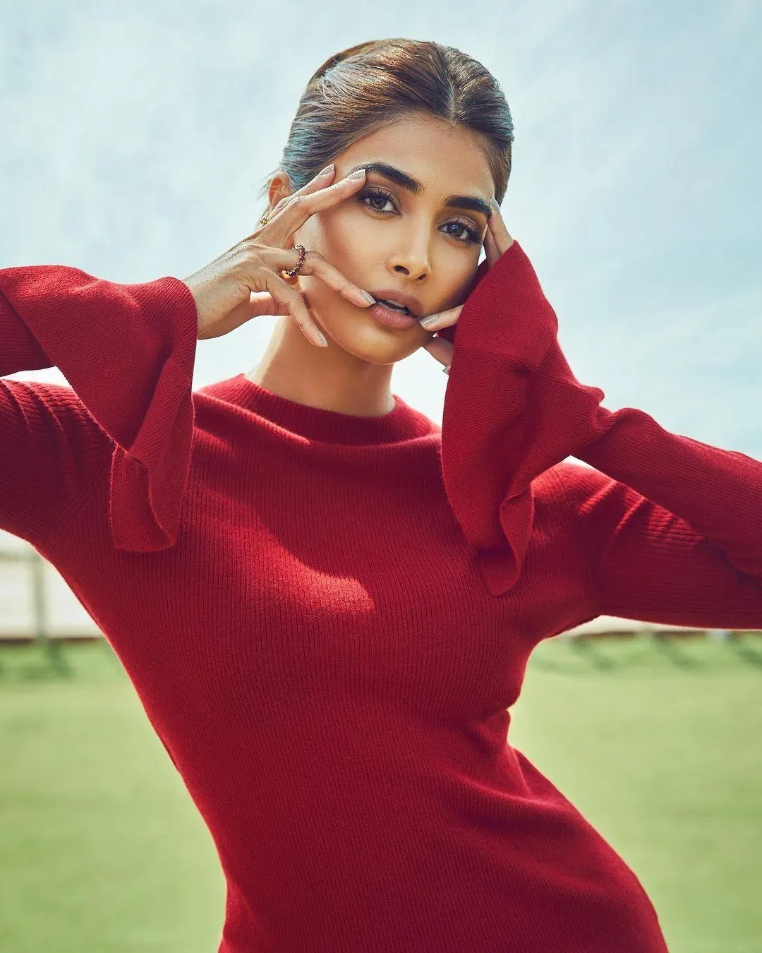 Pooja Hegde in a Stylish Red Top Posing with Hand Near Face