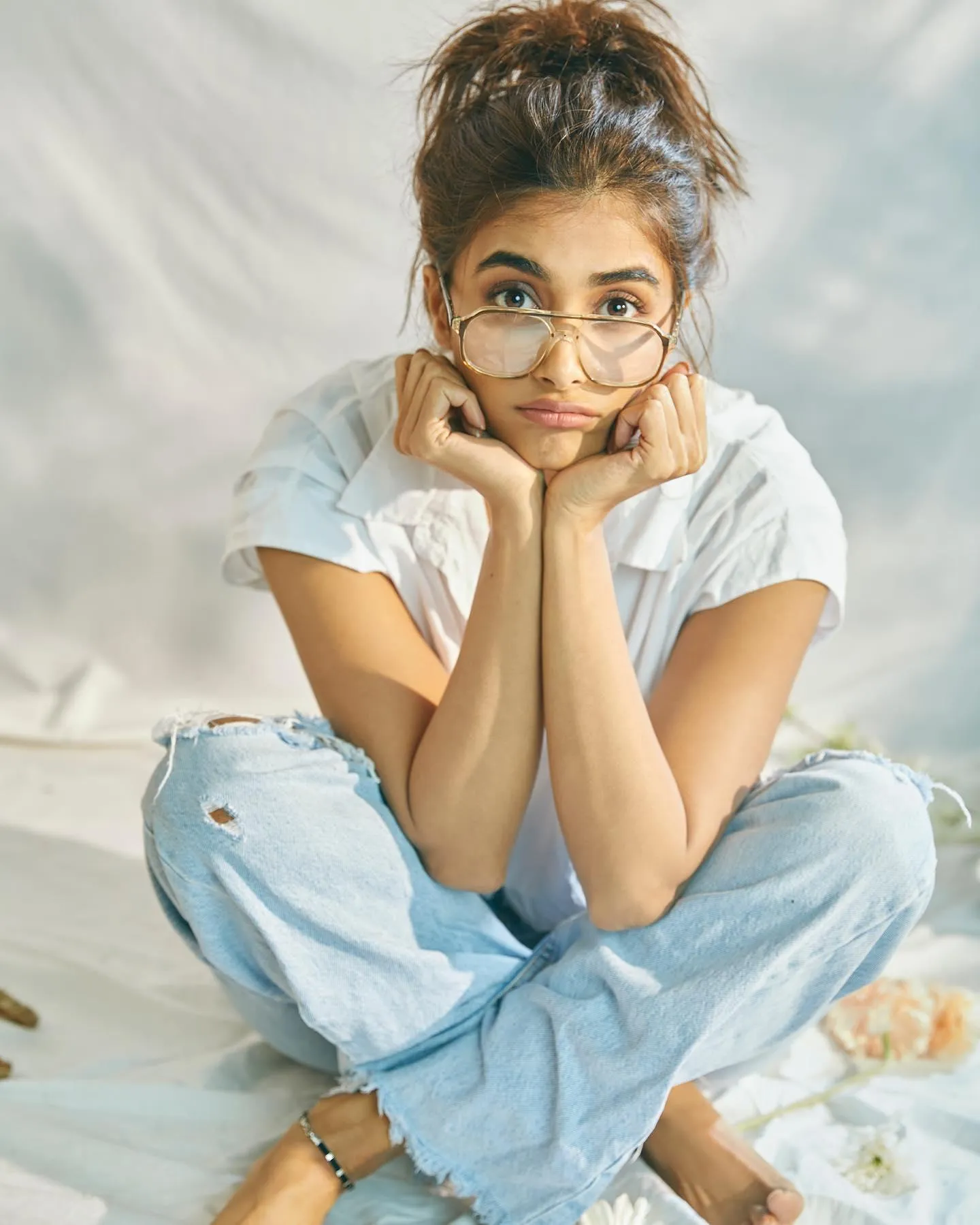 Pooja Hegde in Glasses Sitting in Jeans on the Floor