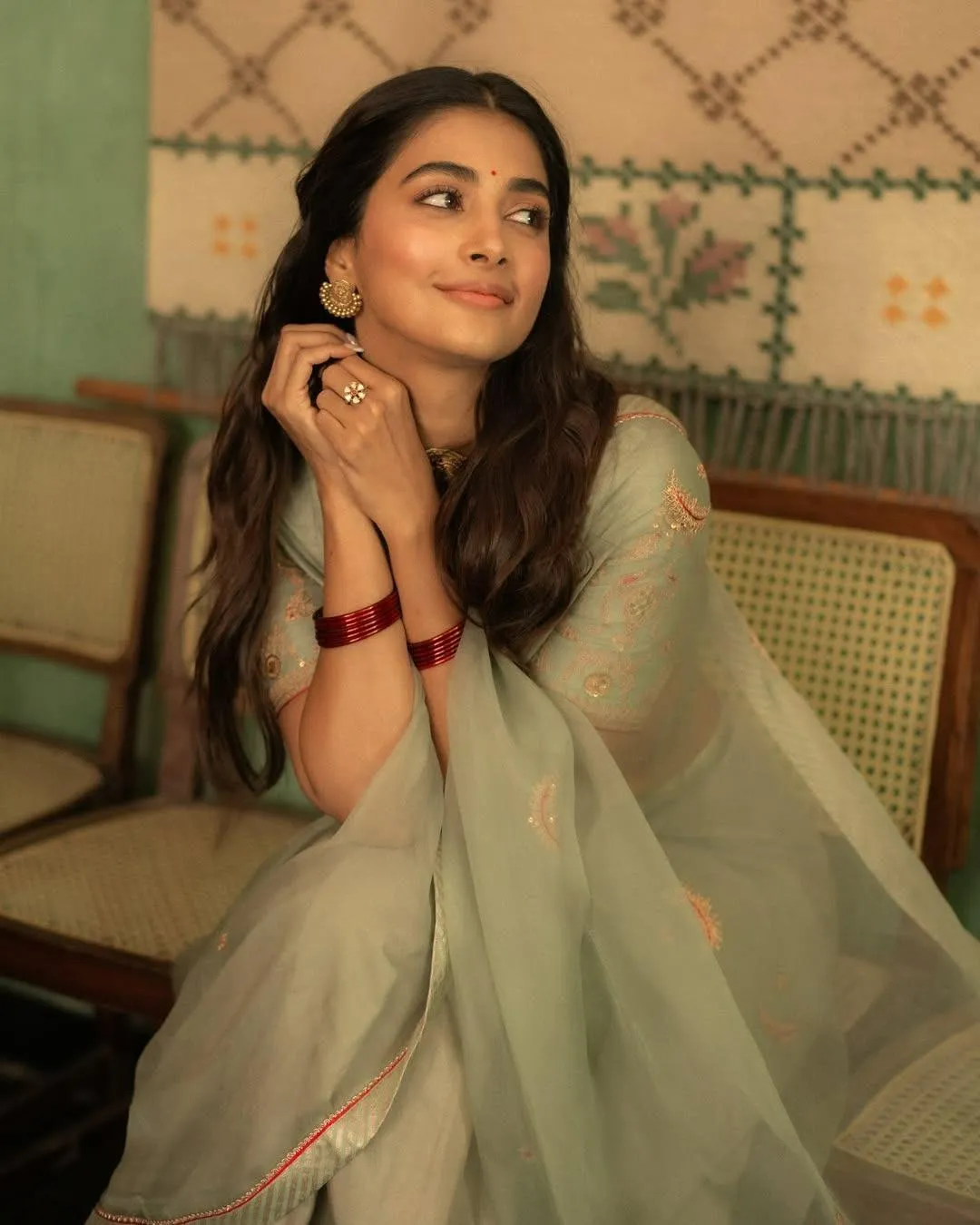 Pooja Hegde in Green Saree Sitting Indoors Peacefully