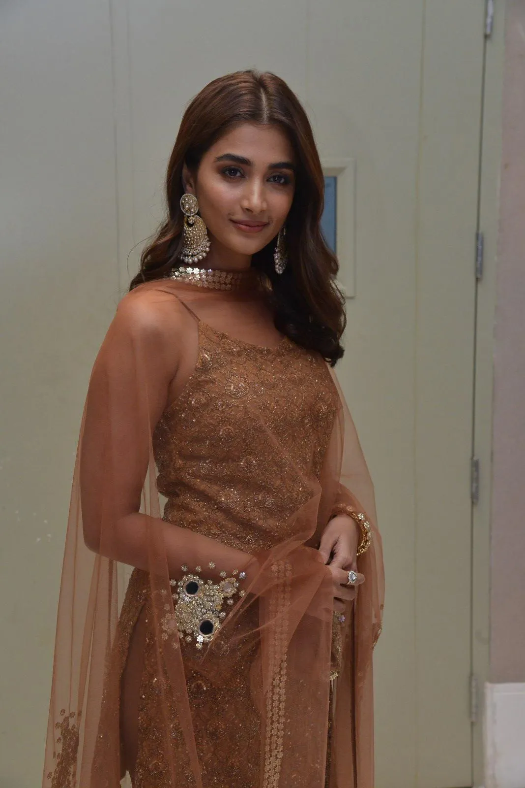 Pooja Hegde in One Shoulder Brown Gown Posing Indoors