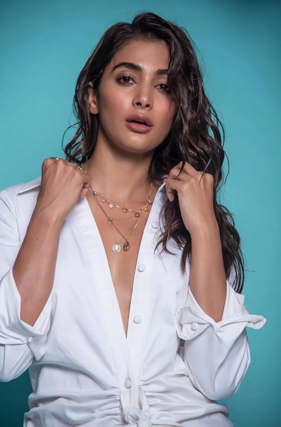 Pooja Hegde in Open White Shirt Against a Blue Background