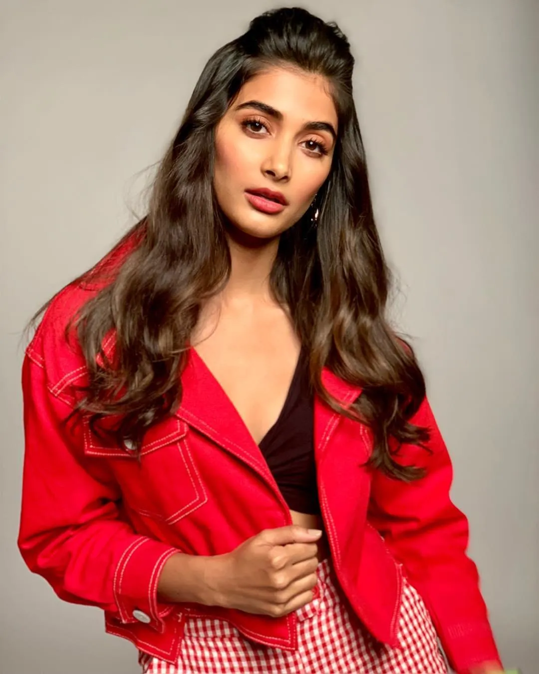 Pooja Hegde in Red Jacket Striking a Confident Pose Image