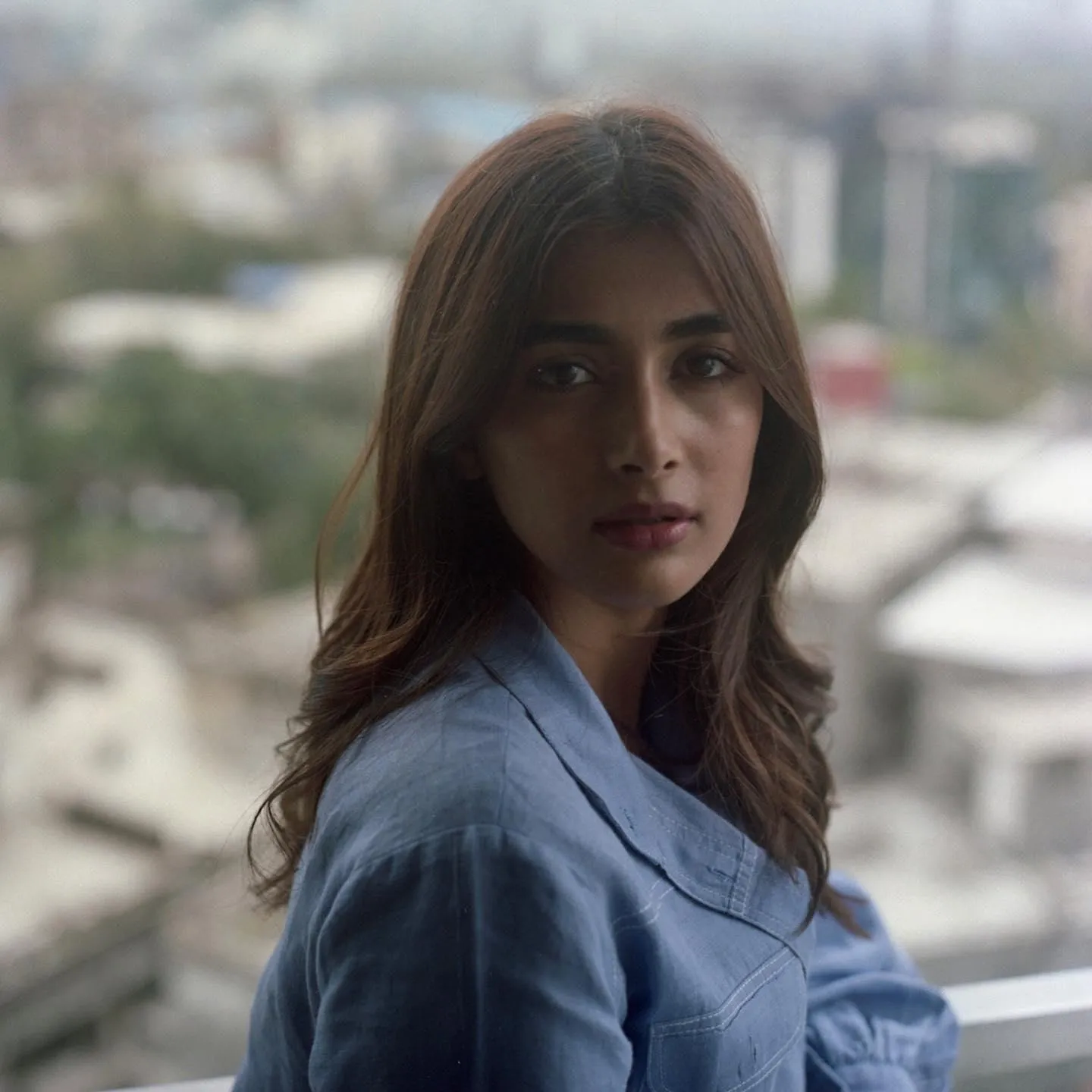 Pooja Hegde Looks Away From Window in Blue Shirt Image