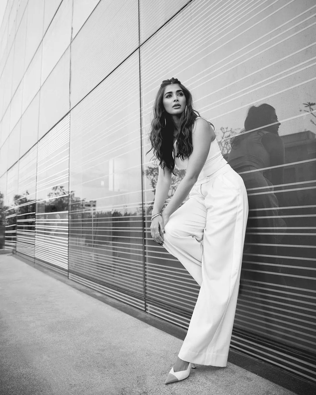 Pooja Hegde Posing in White Outfit Near Glass Wall Outside