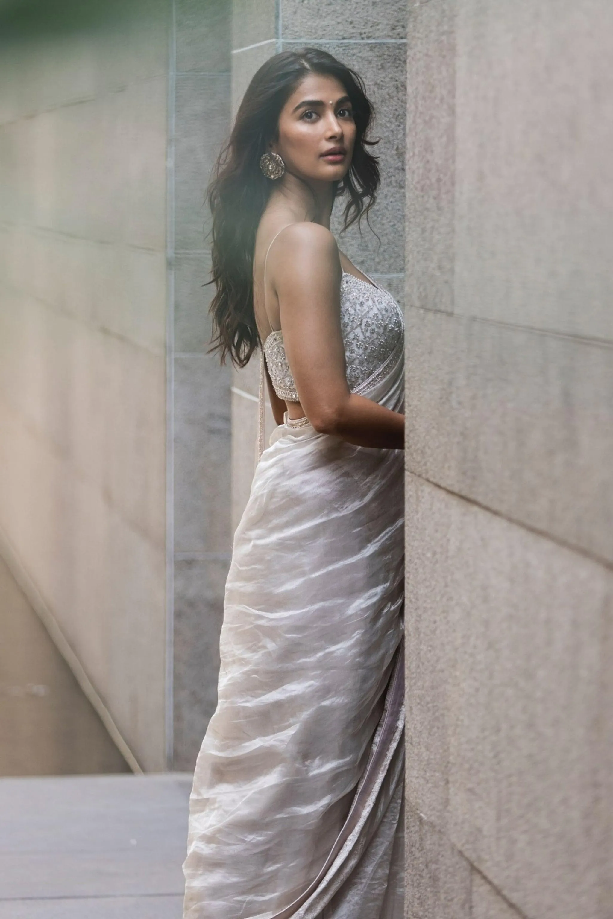 Pooja Hegde Posing Near Wall in Shimmering Silver Gown