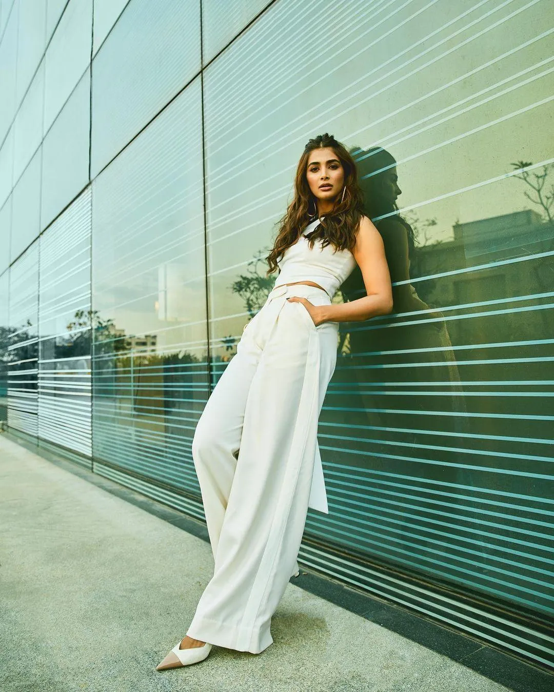 Pooja Hegde Posing Outdoors Wearing White Pants and Top