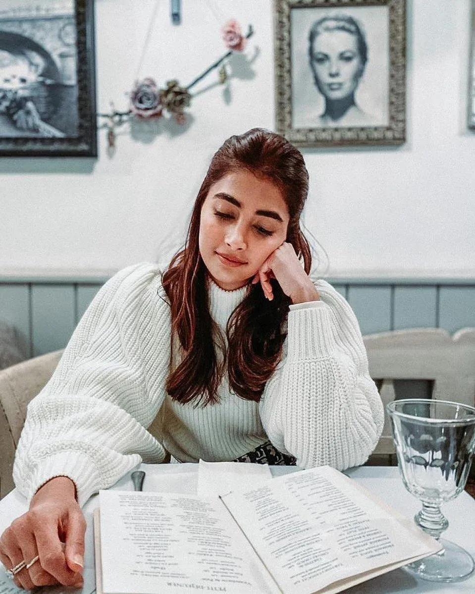Pooja Hegde Reading Menu in Cozy Cafe Atmosphere Wallpaper