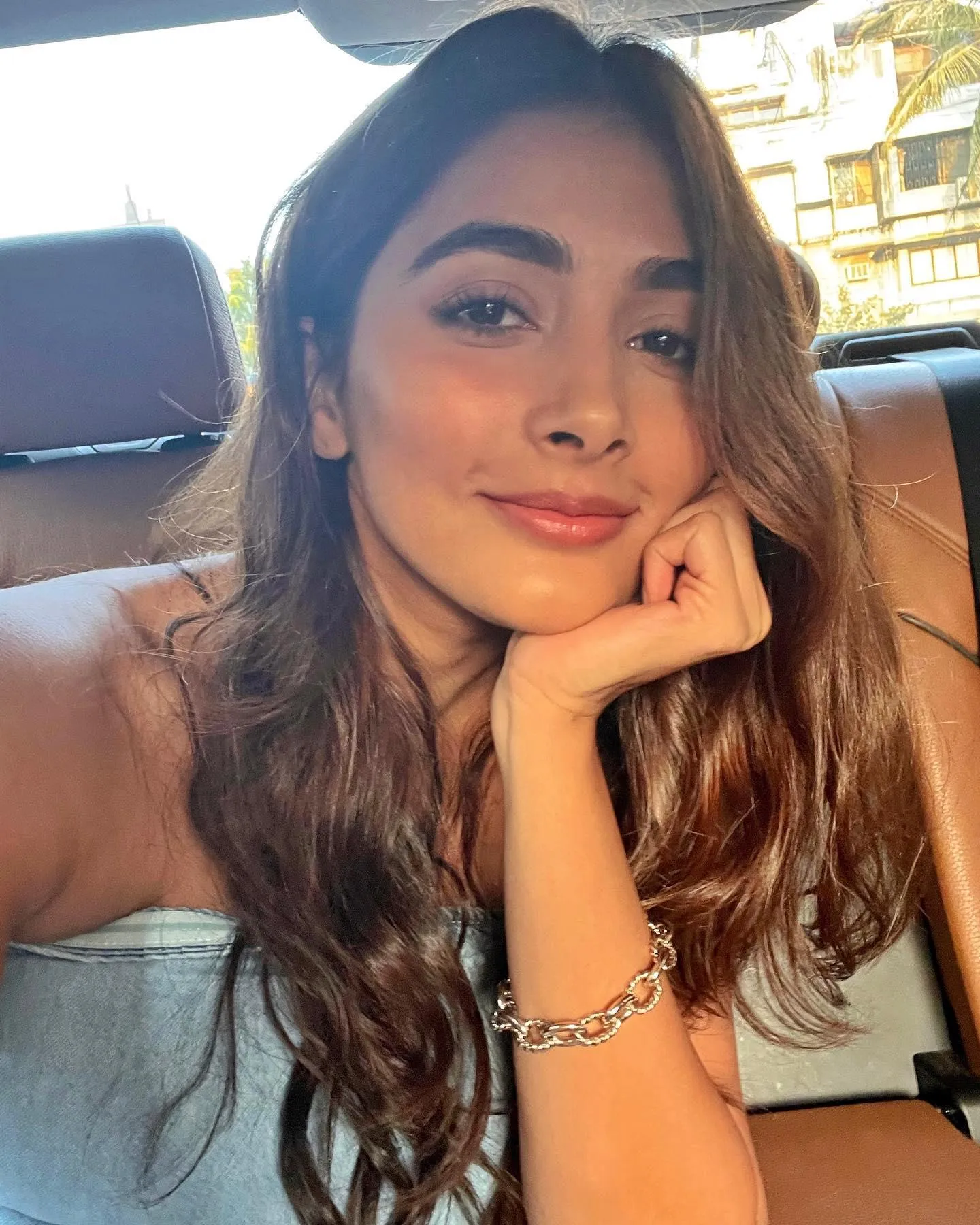 Pooja Hegde Resting Chin on Hand While Smiling in Car