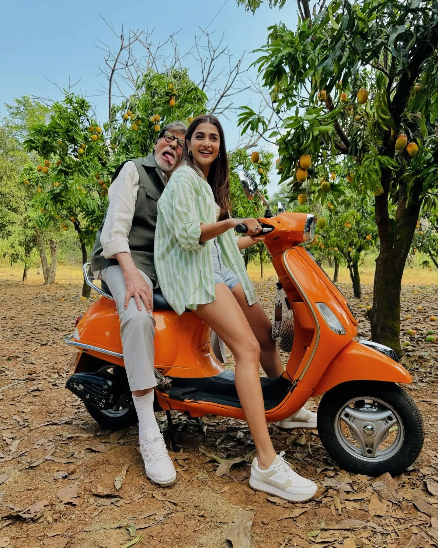 Pooja Hegde Riding Orange Scooter Smiling with Companion