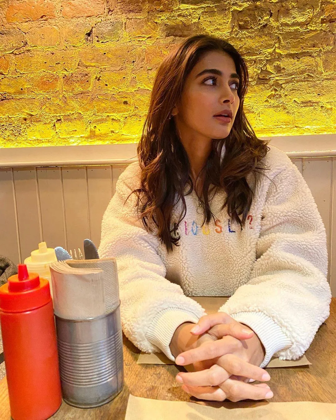Pooja Hegde Sitting At a Cafe in Cozy Winter Wear Wallpaper