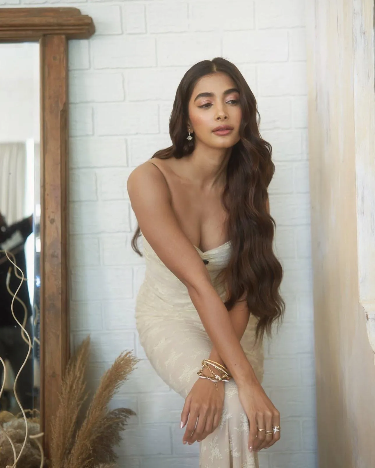 Pooja Hegde Sitting Gracefully in a Modern White Dress