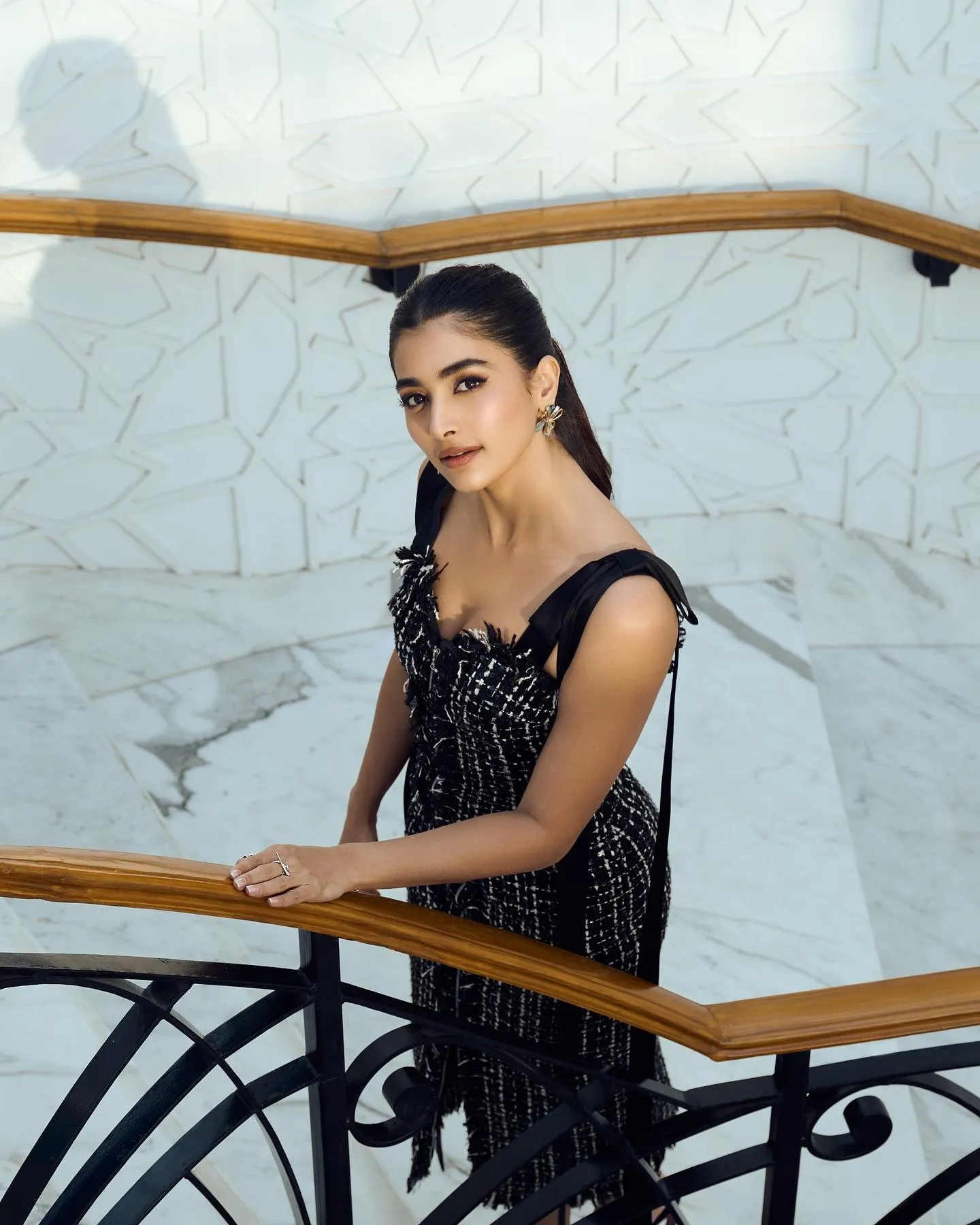 Pooja Hegde Sitting Gracefully on Staircase in Black Image