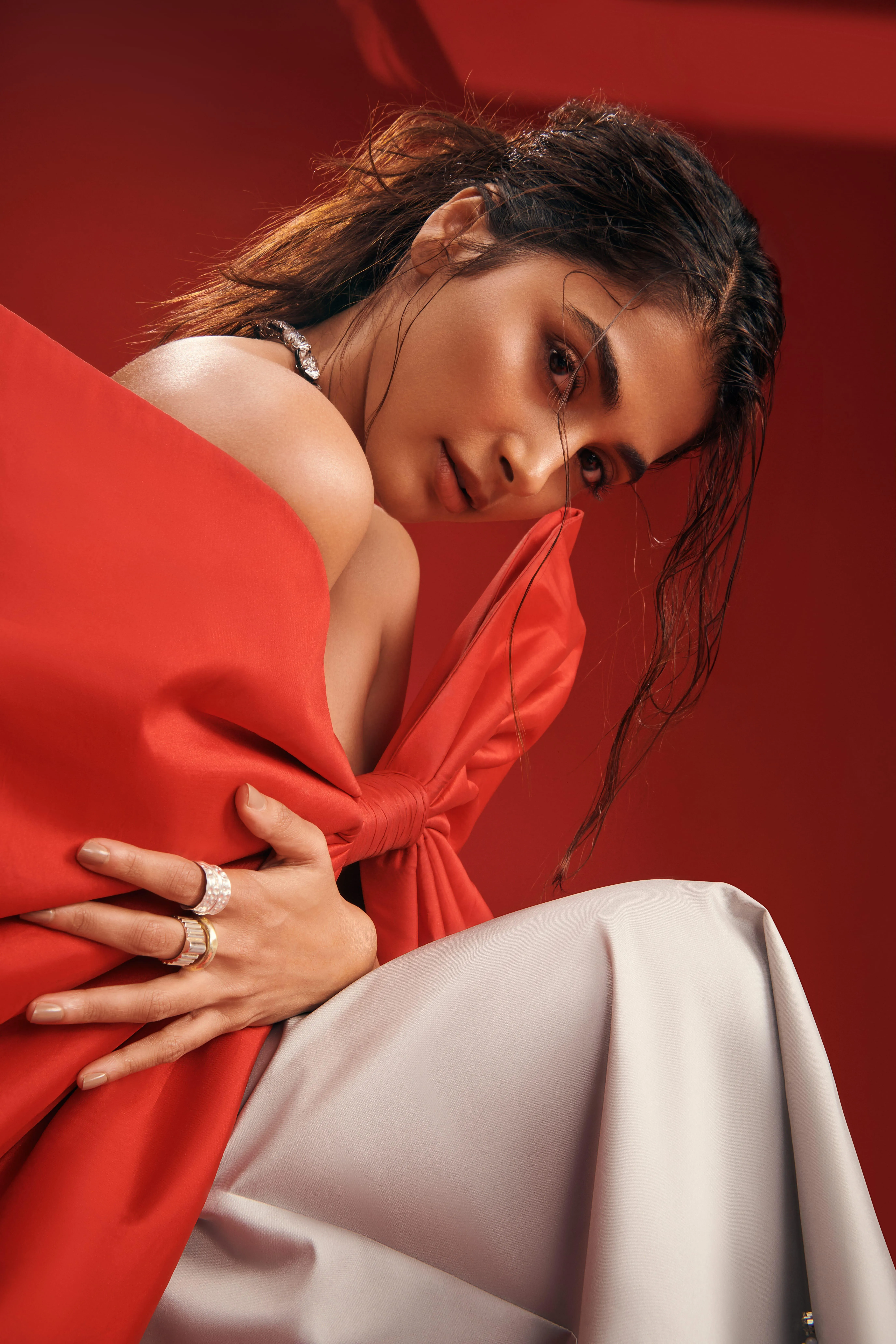 Pooja Hegde Sitting in Red Top and White Pants Elegance