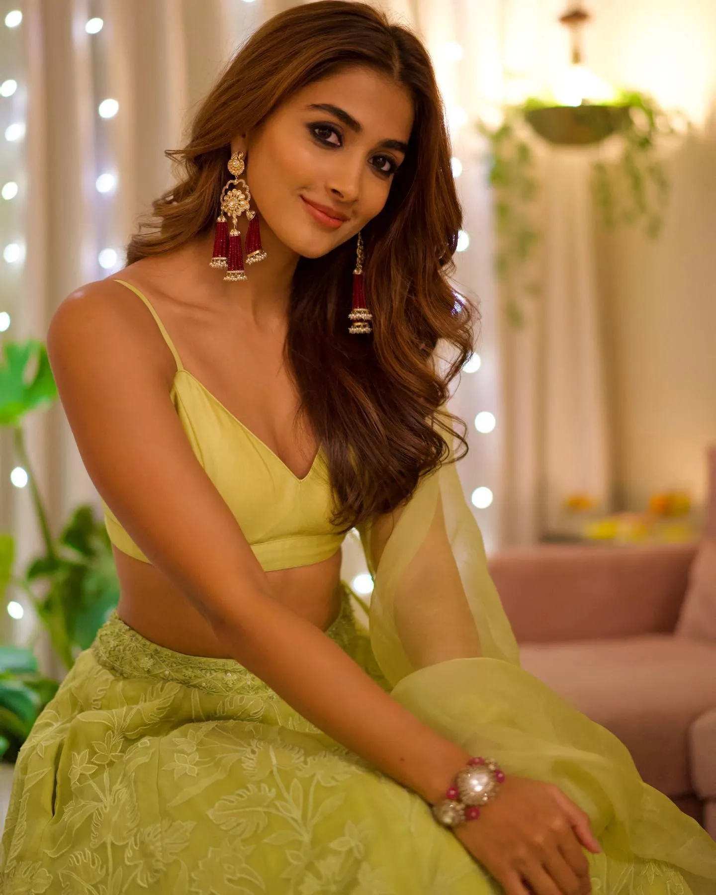 Pooja Hegde Sitting Indoors Wearing a Yellow Dress Image
