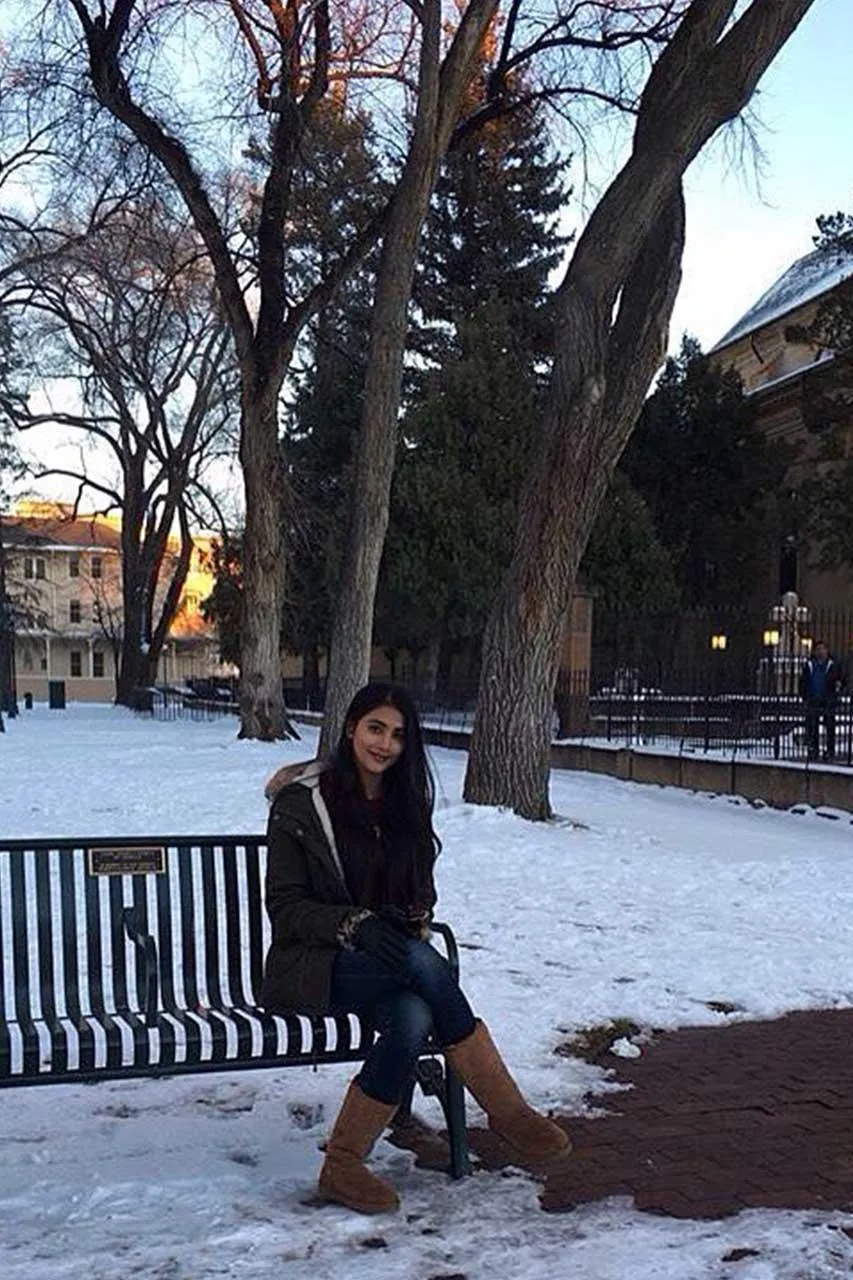 Pooja Hegde Sitting on a Bench in a Snowy Park Wallpaper