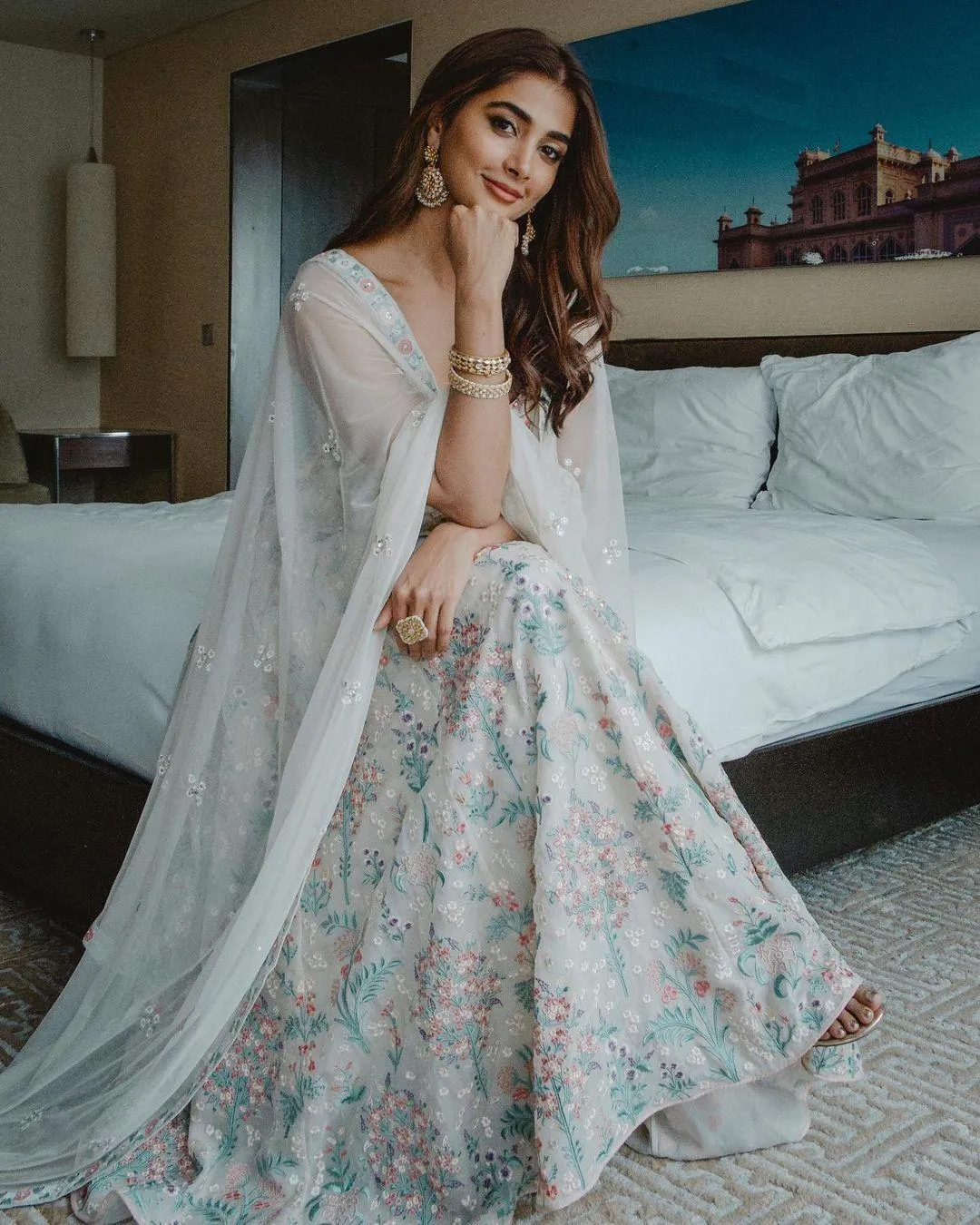 Pooja Hegde Sitting on Bed Wearing Elegant Pastel Colored Dress