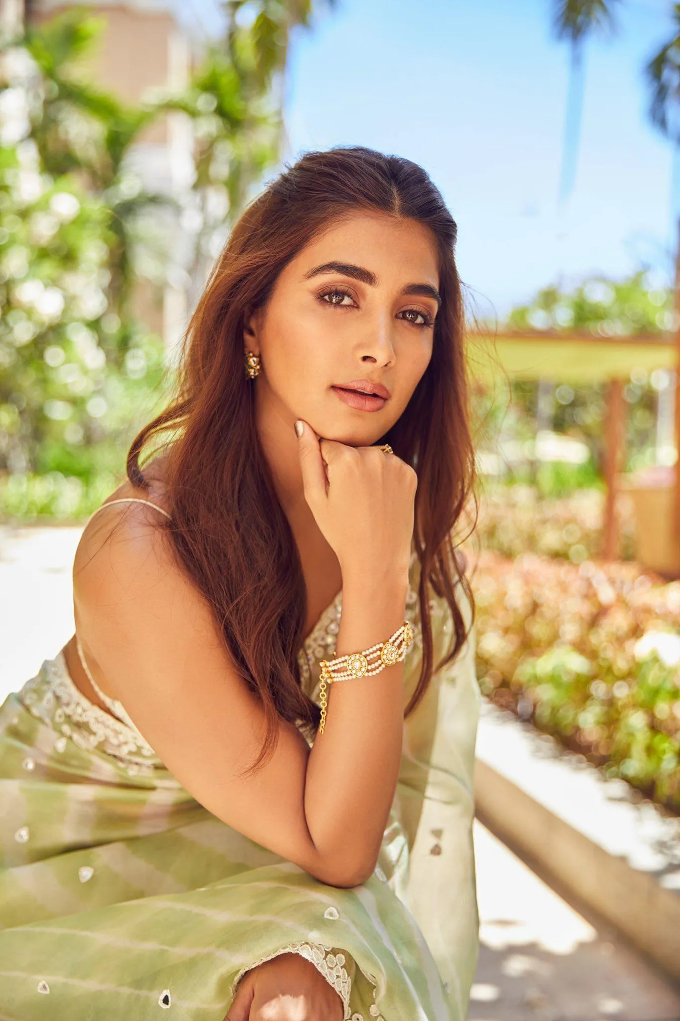 Pooja Hegde Sitting Outdoors Wearing Light Dress and Jewelry