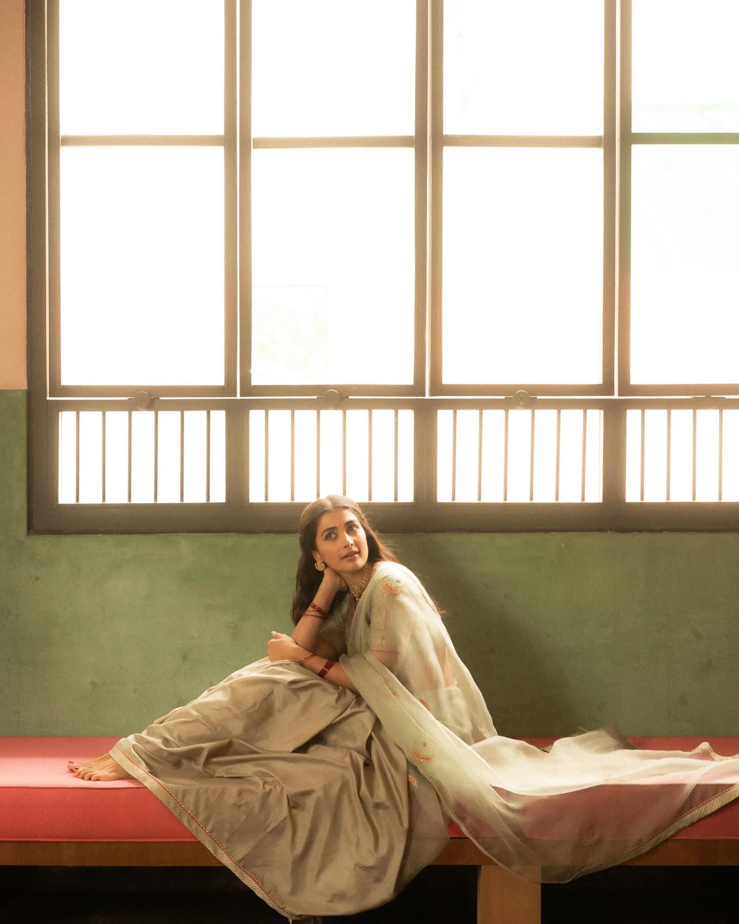 Pooja Hegde Sitting Peacefully By Window in Saree Image