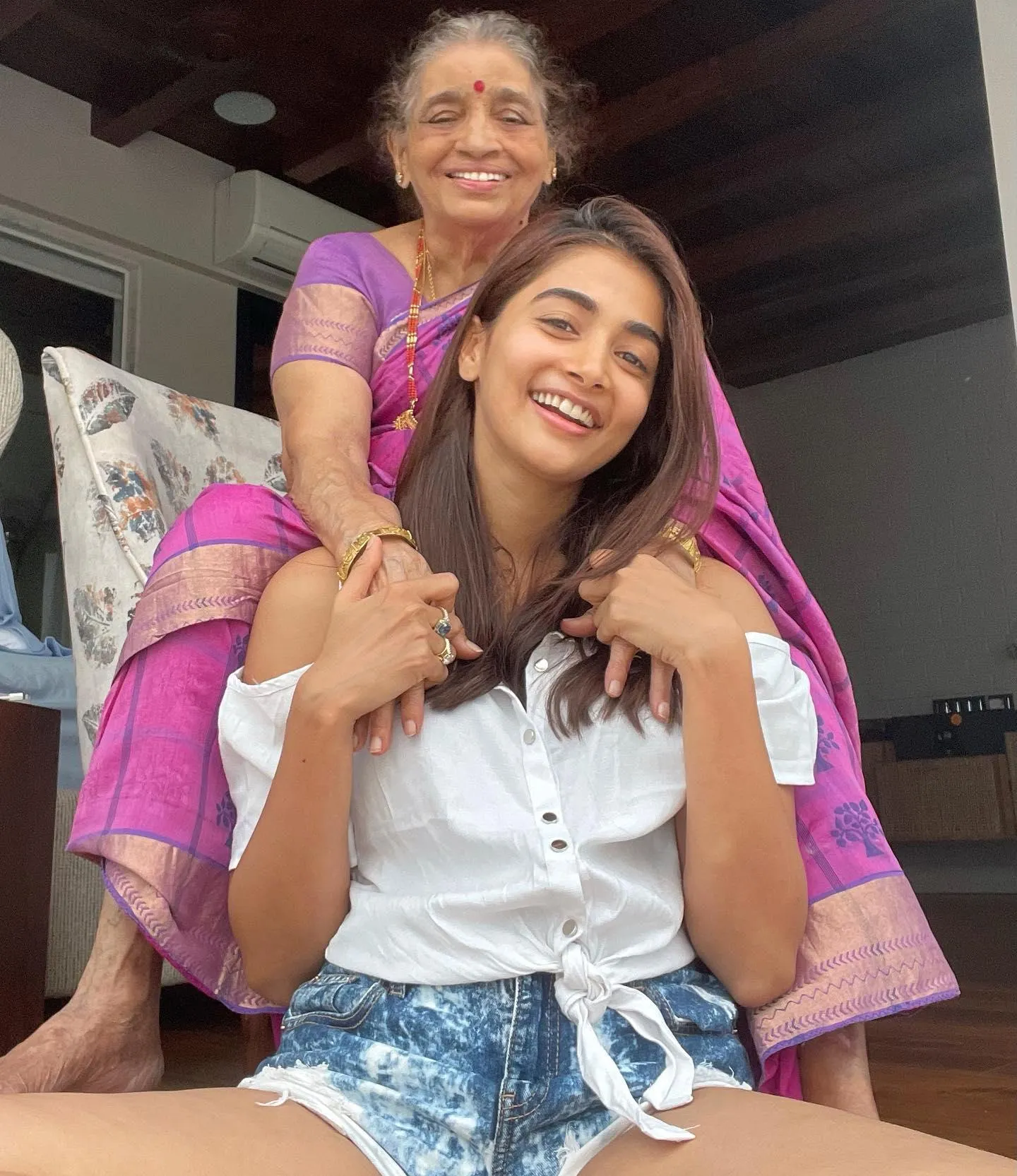 Pooja Hegde Smiles with Grandmother on Her Back Image