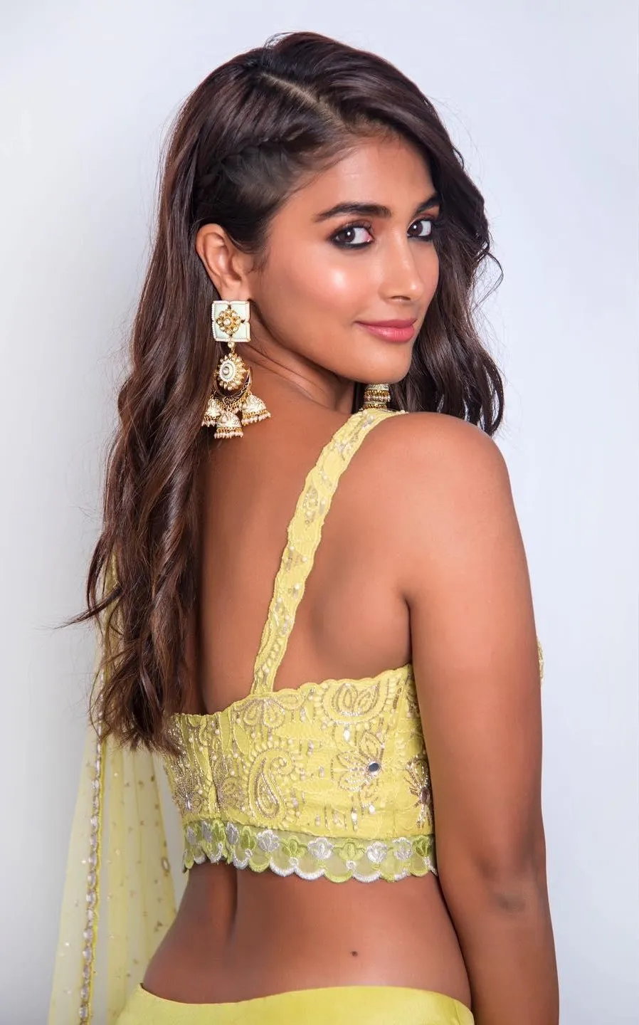 Pooja Hegde Smiling in Yellow Backless Blouse and Earrings