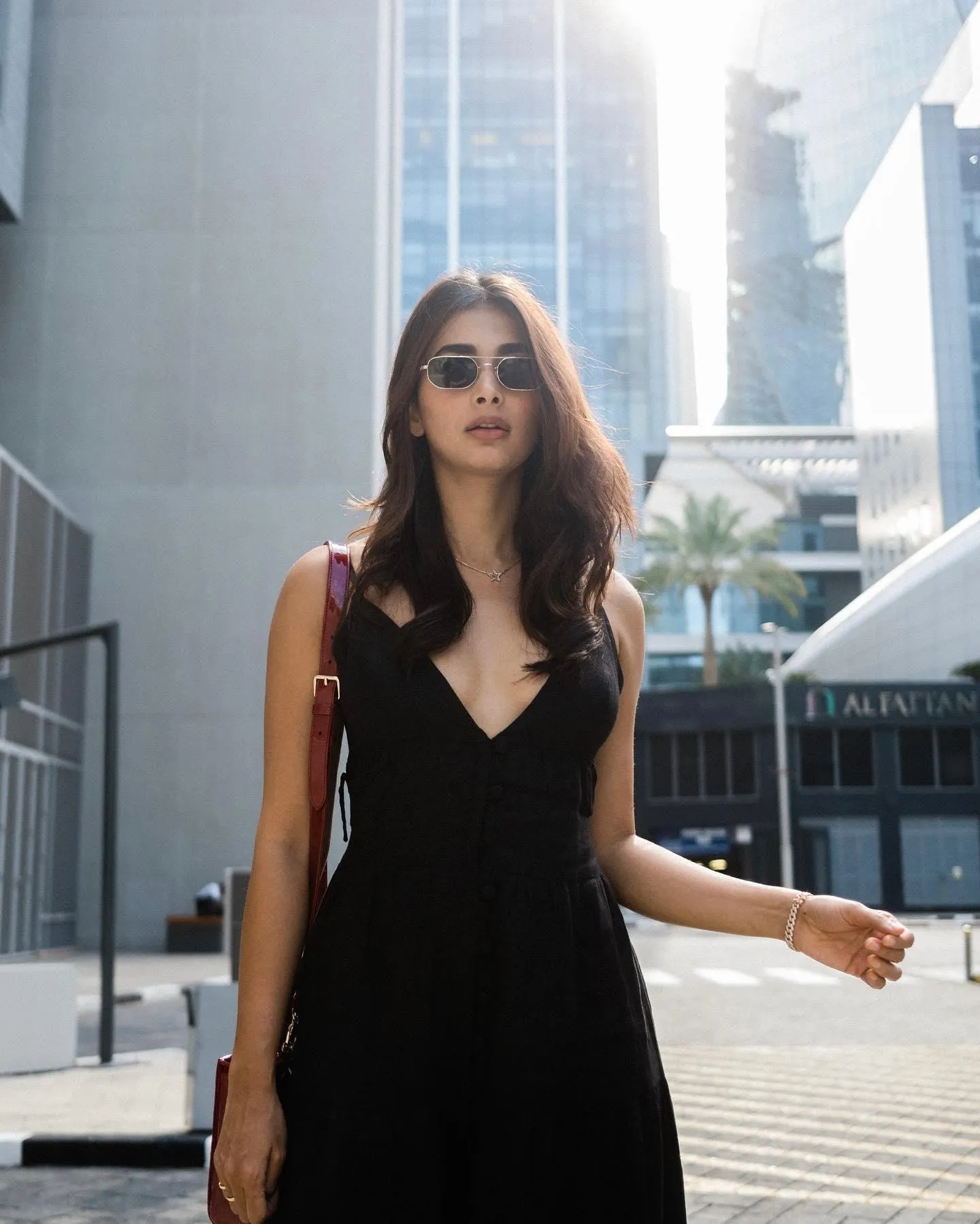 Pooja Hegde Walking in Black Dress Under City Sunlight