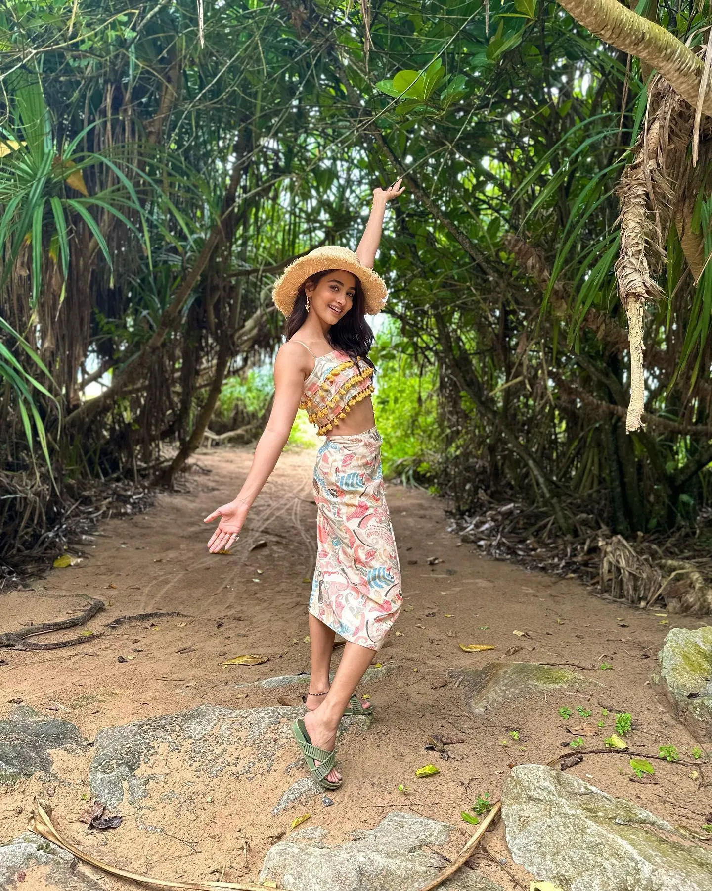 Pooja Hegde Walking in Tropical Garden Wearing Hat and Dress