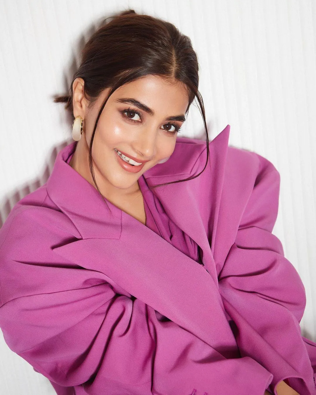 Pooja Hegde Wrapped in Pink Jacket Smiling with Soft Curls