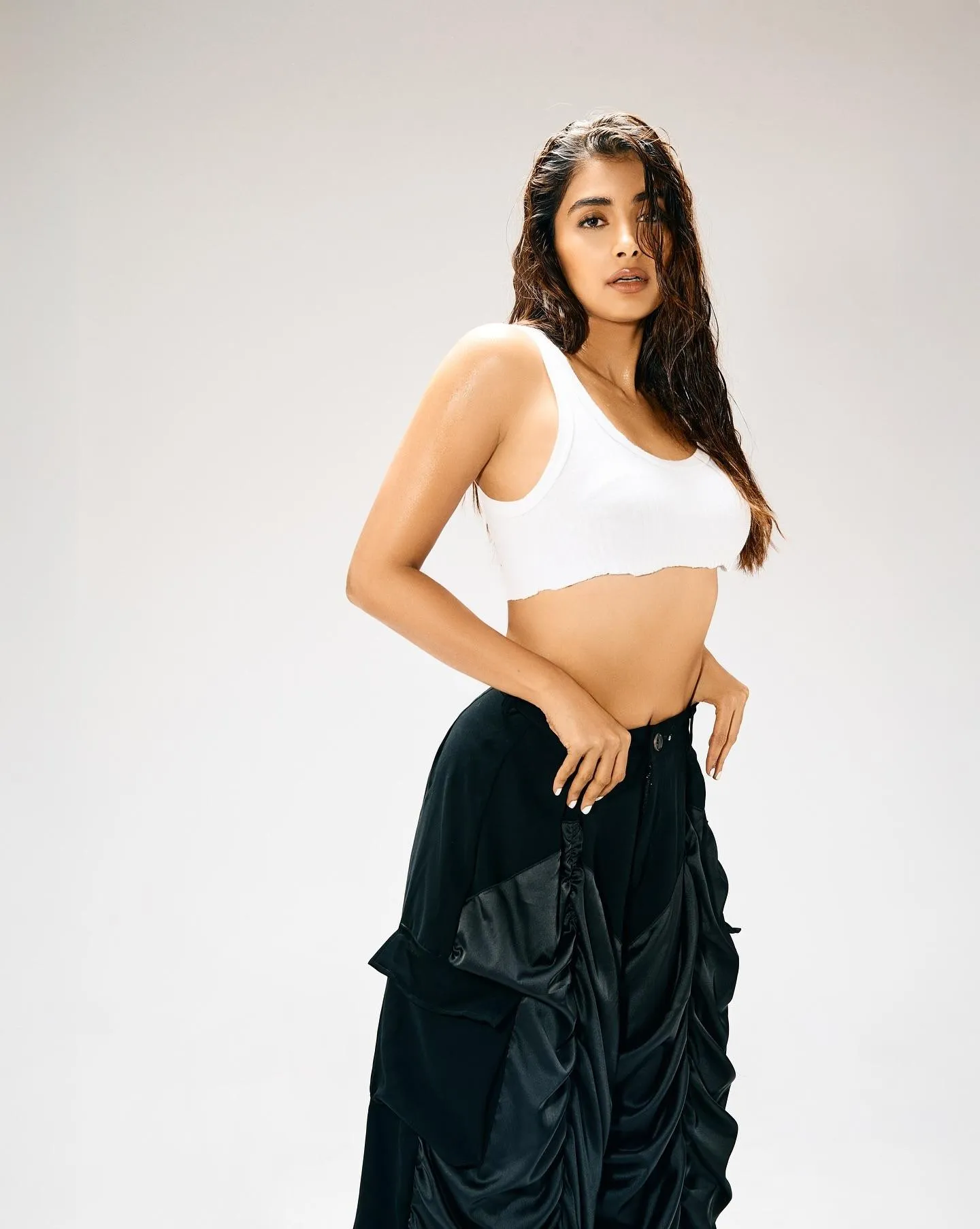 Stylish Pooja Hegde in White Crop Top and Black Skirt Pose