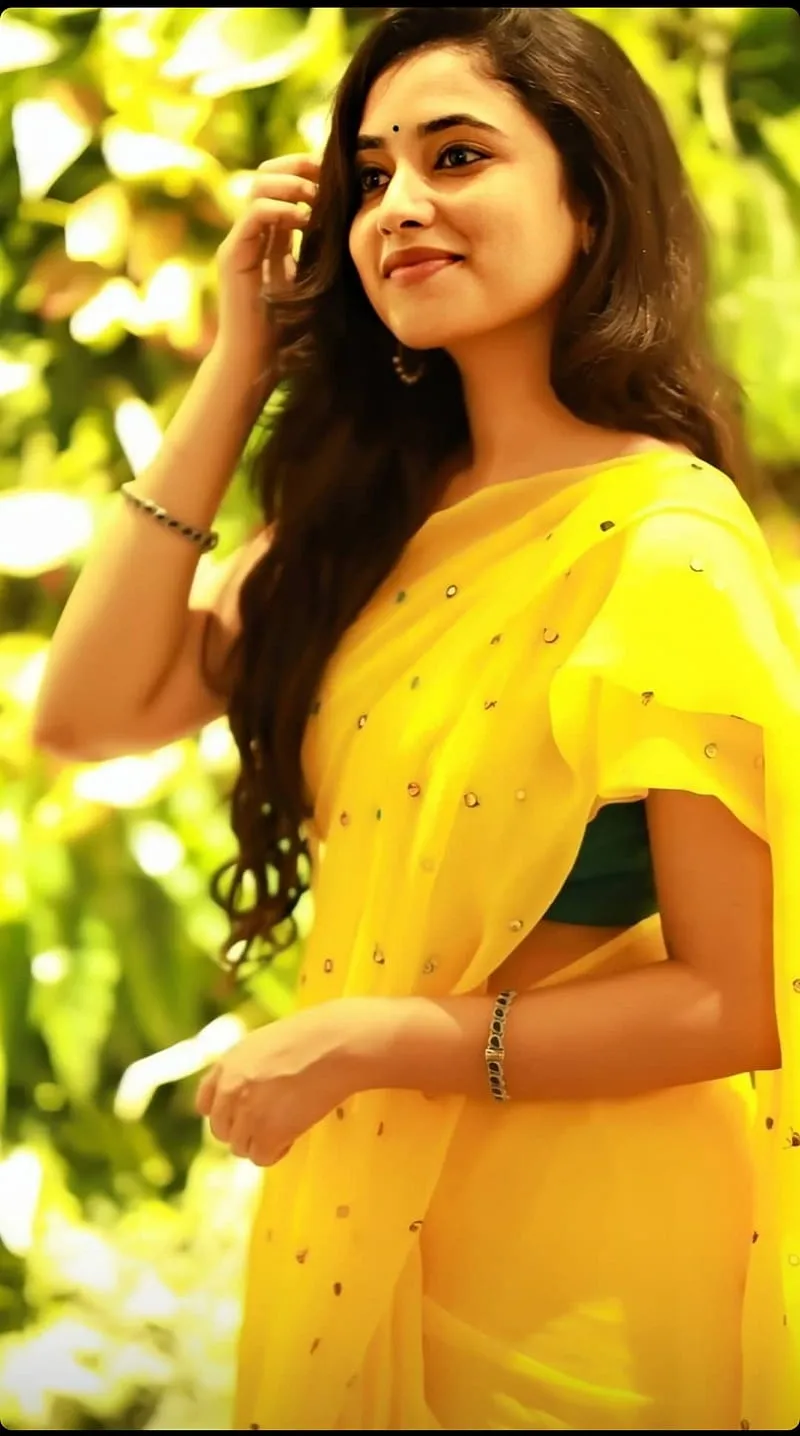 Actress Priyanka in bright yellow dress smiling in garden