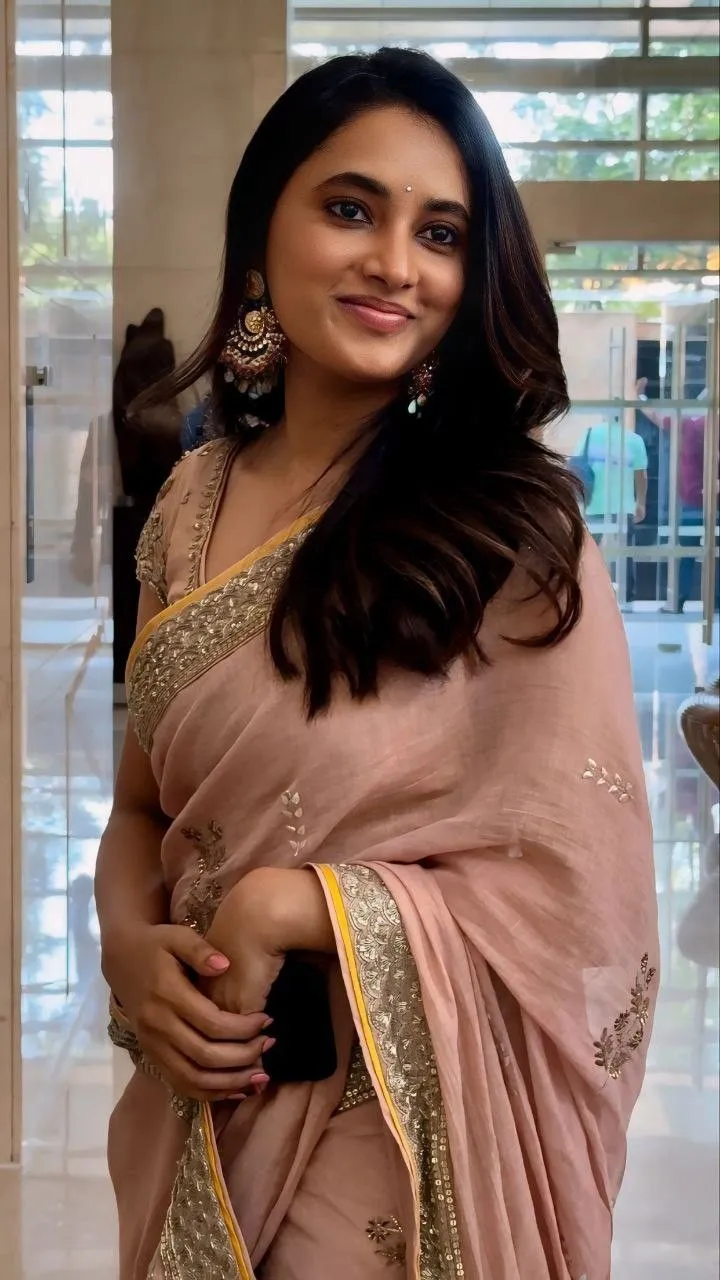 Actress Priyanka in peach saree with a warm smile Wallpaper