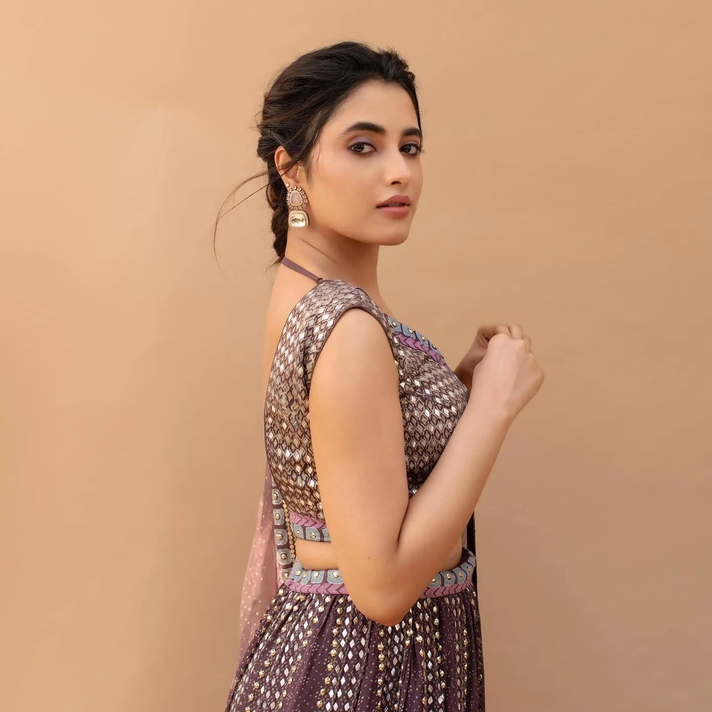 Actress Priyanka in sleeveless brown dress with side glance