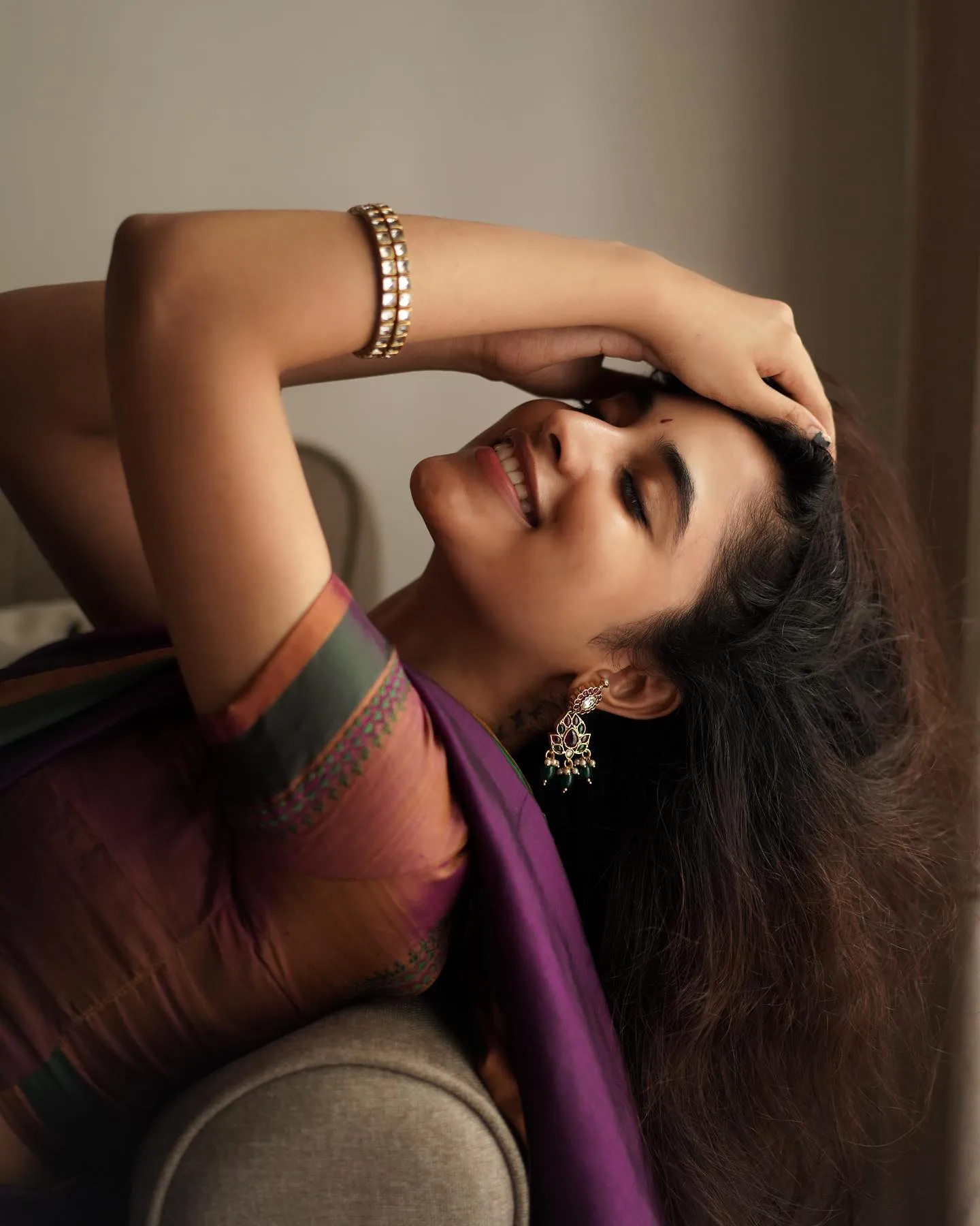 Elegant Pose of Priyanka Arul Mohan on a Couch Wallpaper