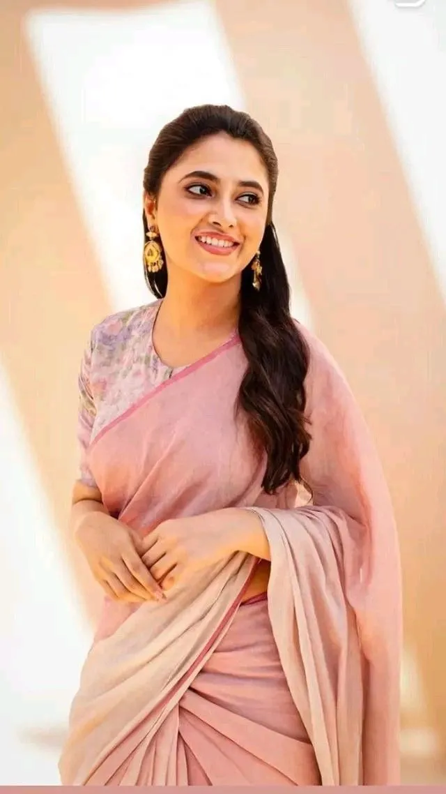 Portrait of Priyanka Arul Mohan smiling in pastel pink saree