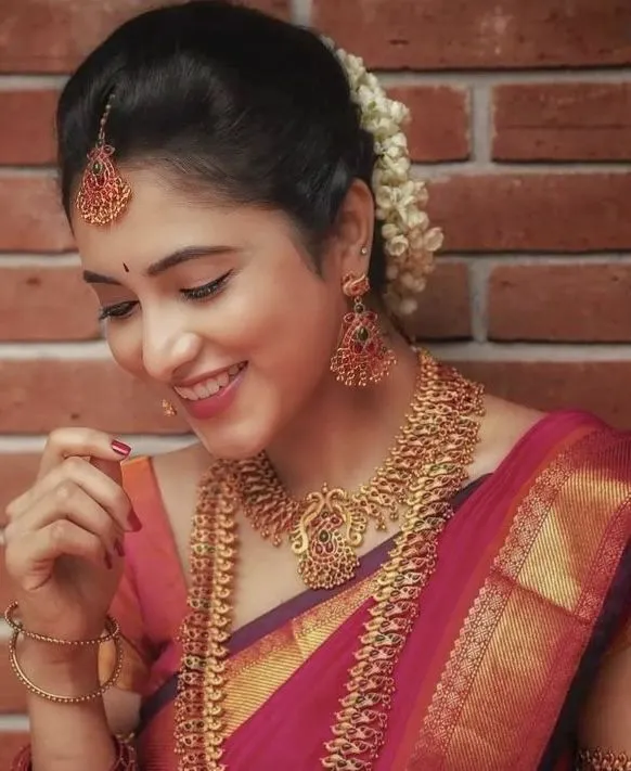 Priyanka Arul Mohan cheerful in red and gold traditional wear