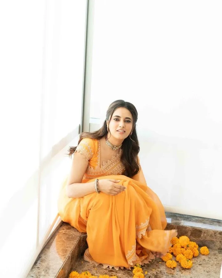 Priyanka Arul Mohan in orange Sitting pose HD Wallpaper