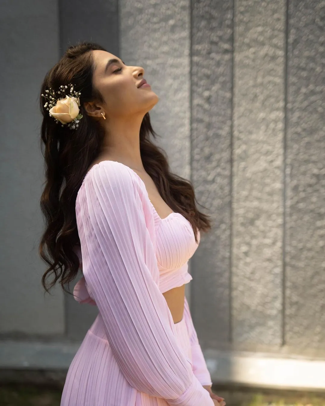 Priyanka Arul Mohan looking up joyfully in light pink outfit