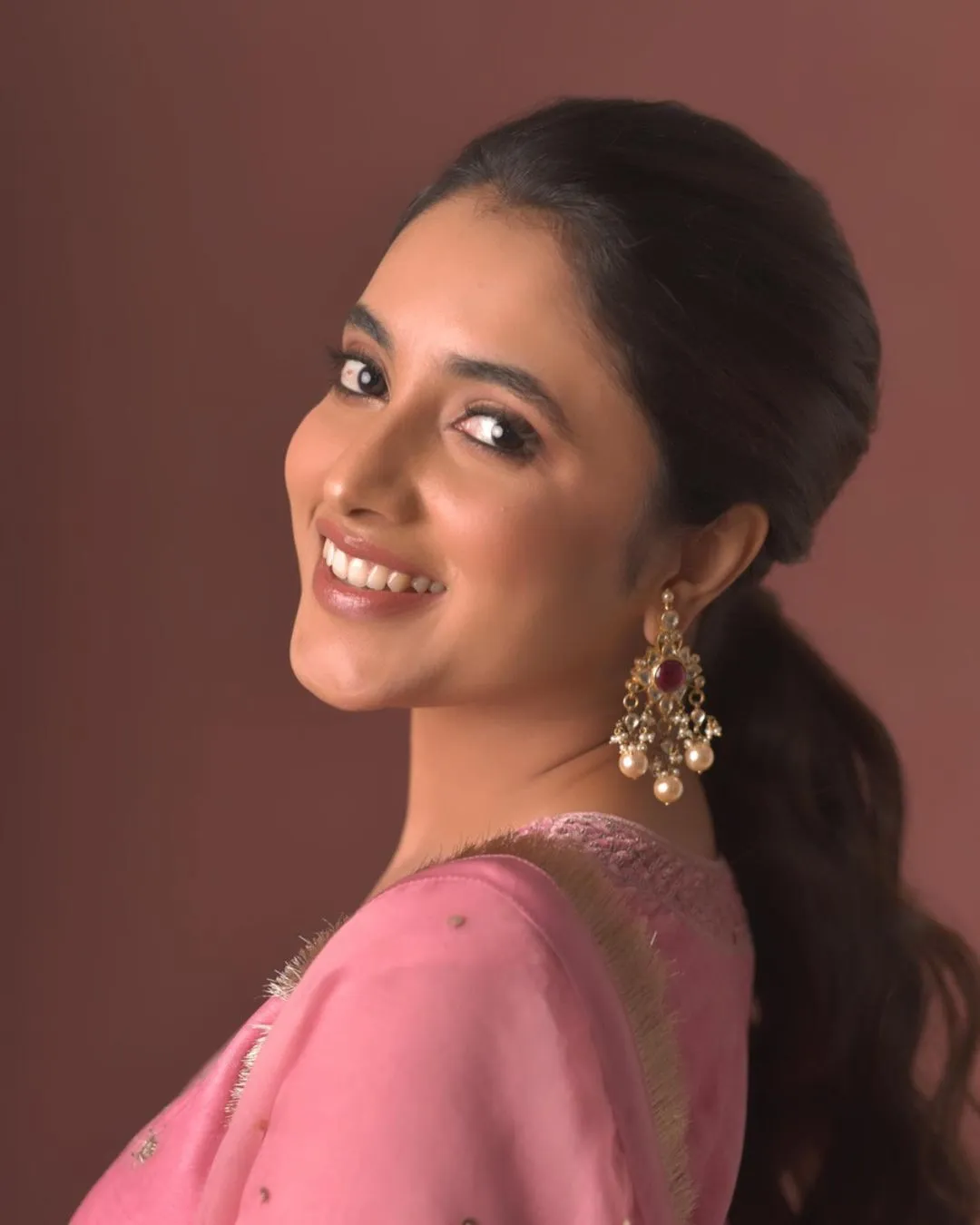 Priyanka Arul Mohan smiling brightly in pink dress look