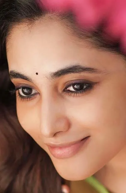 Priyanka Arul Mohan soft smile closeup with pink flowers