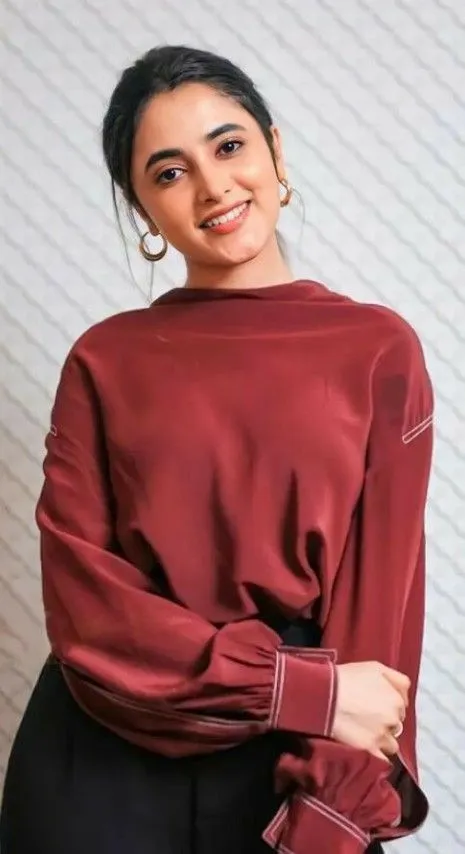 Priyanka Arul Mohan standing pose in maroon jacket image