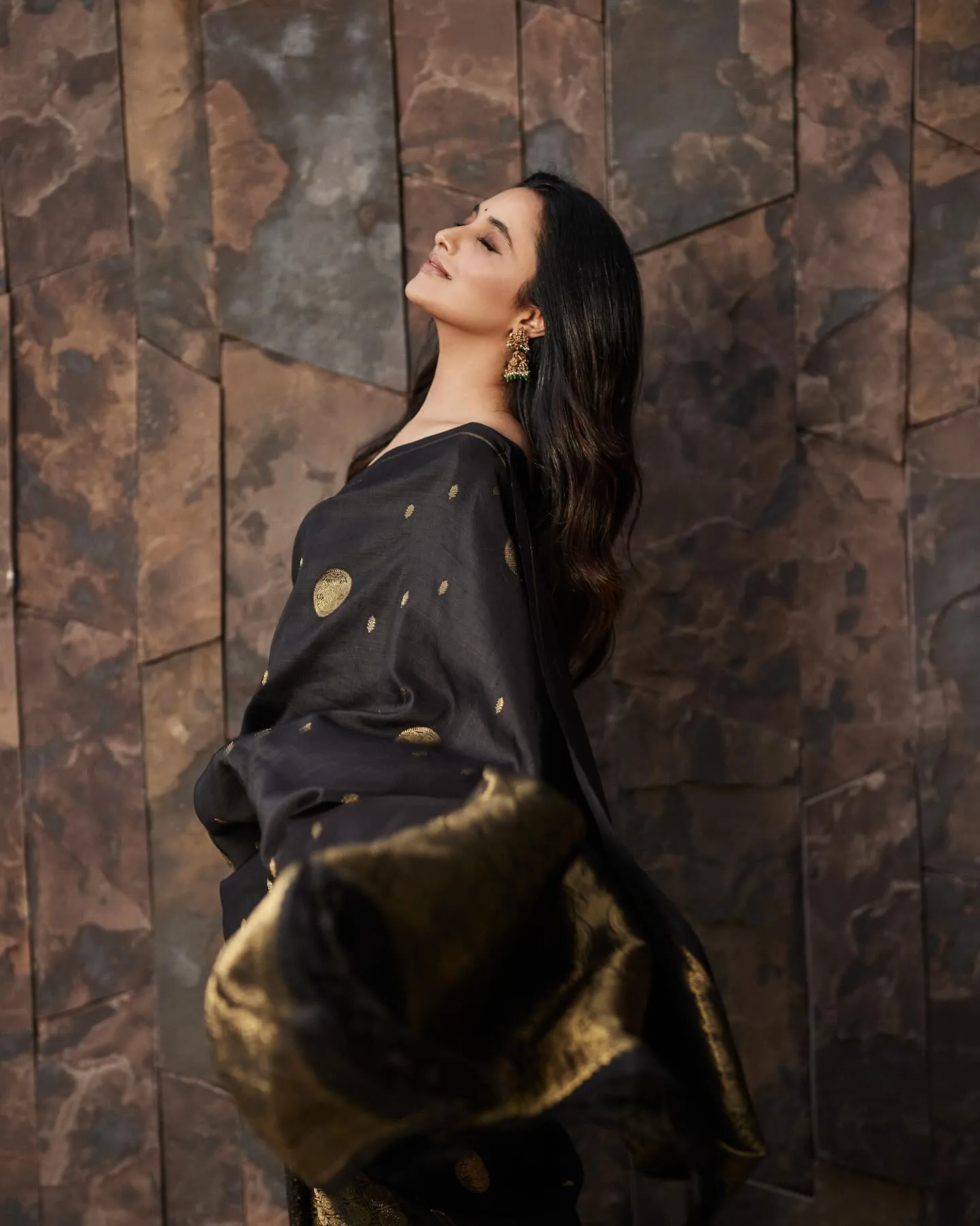 Priyanka Arul Mohan striking pose in black designer saree