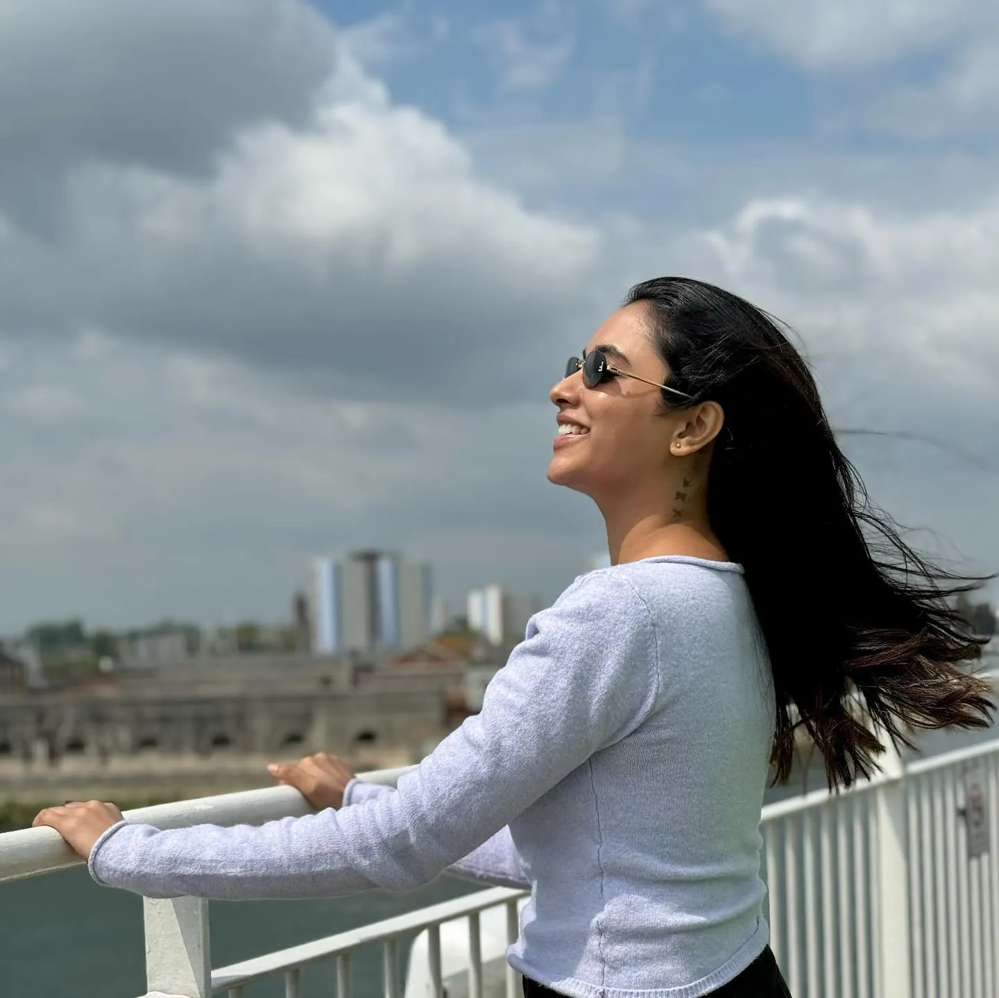 Priyanka enjoying fresh air outside with a city view HD