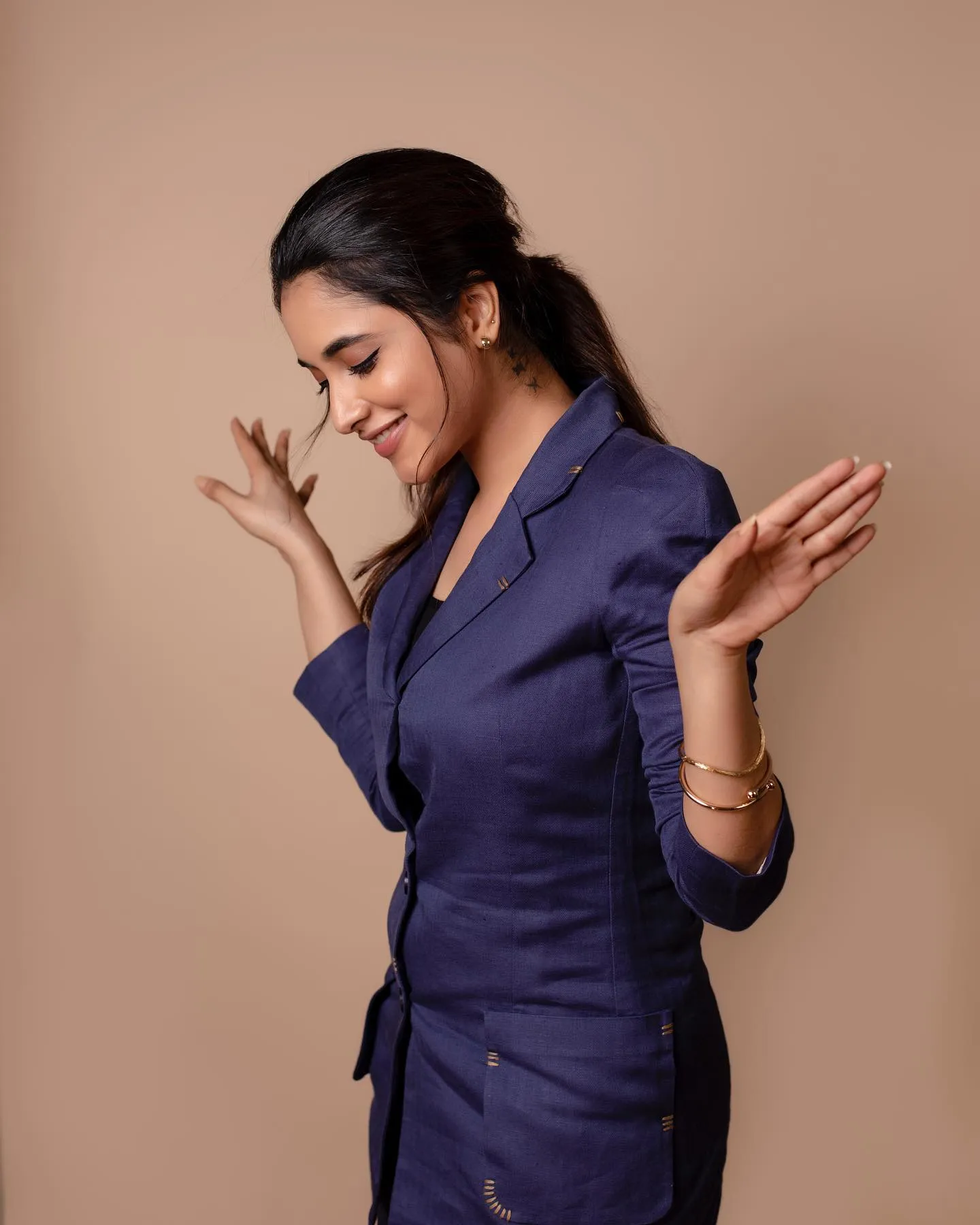 Priyanka in blue formal outfit looking down Wallpaper