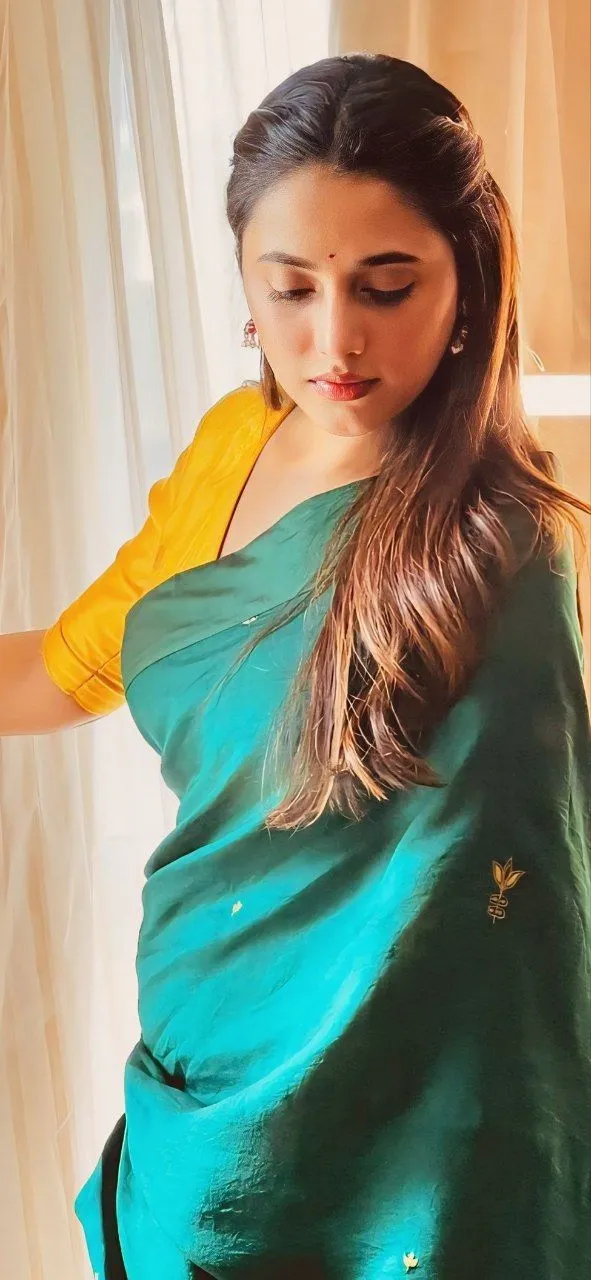 Priyanka in green saree with orange blouse looking down