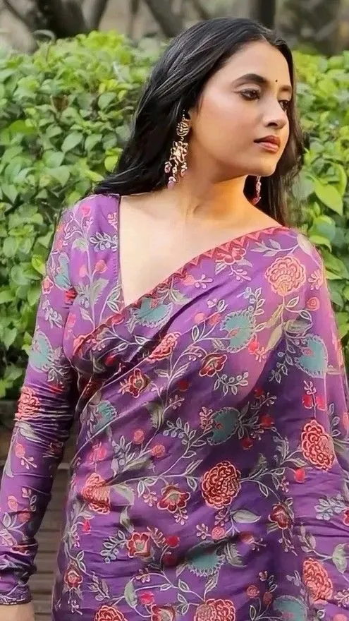 Priyanka in purple saree smiling slightly outdoors image